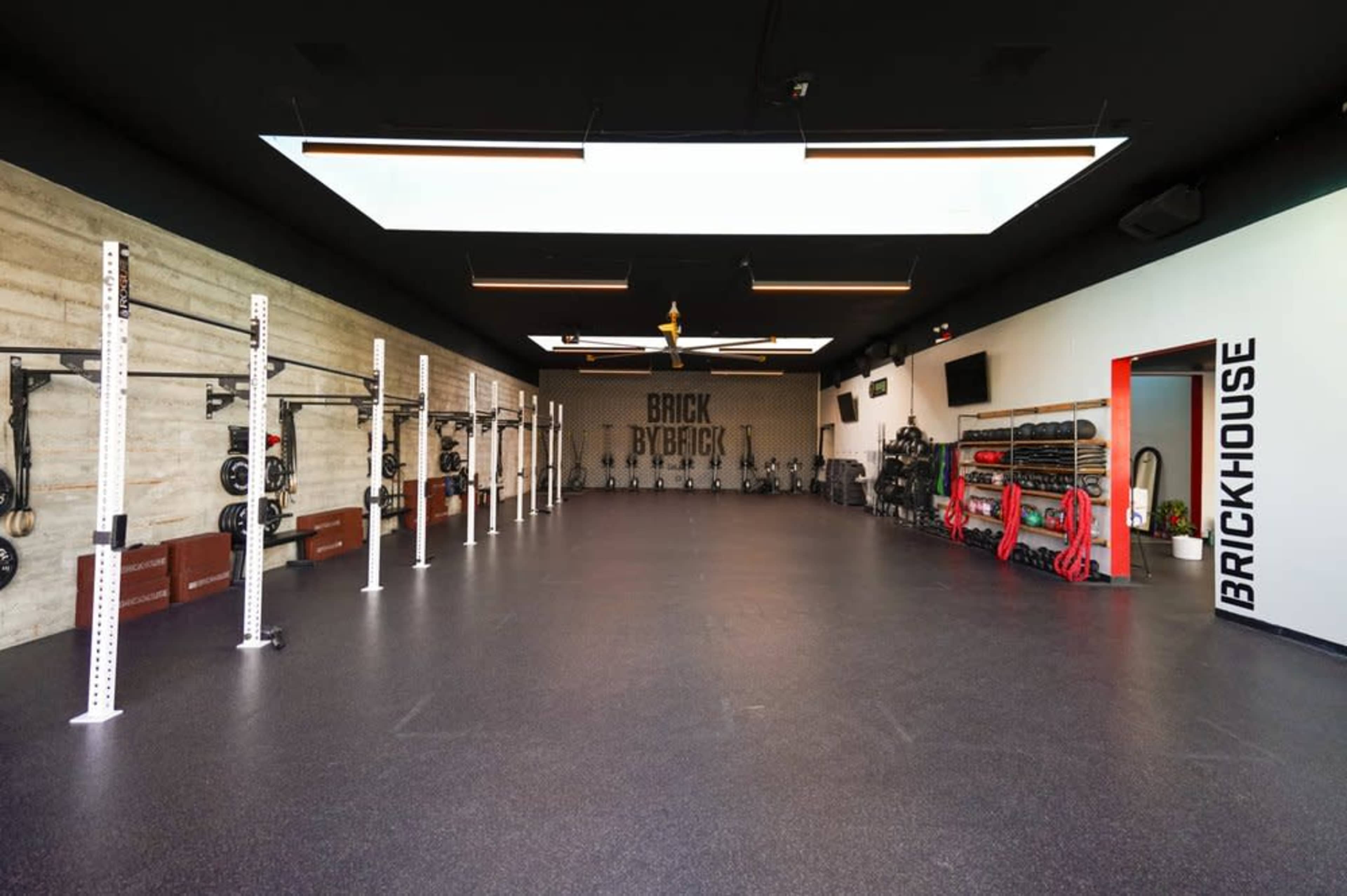 A spacious fitness studio equipped with various weightlifting stations and exercise equipment.
