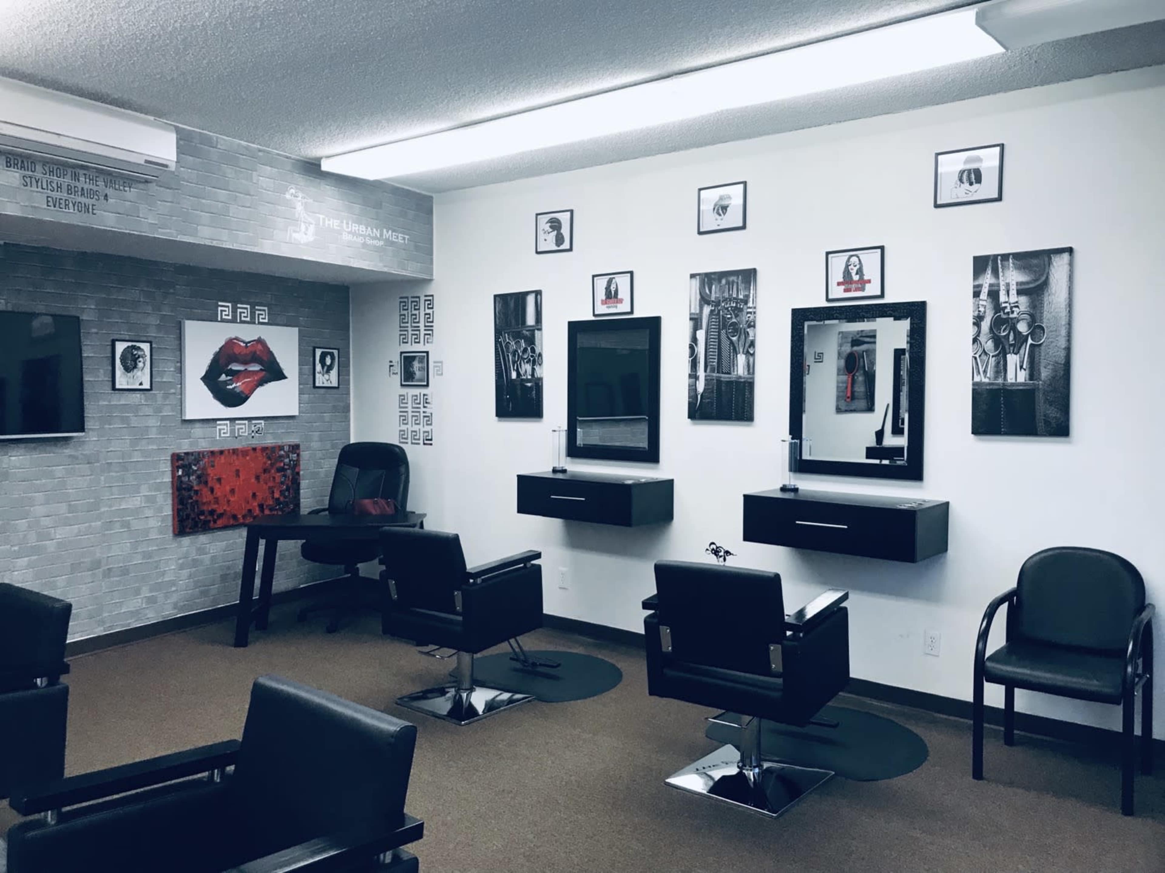 A hair salon with several styling chairs, mirrors, and framed artworks on the walls.