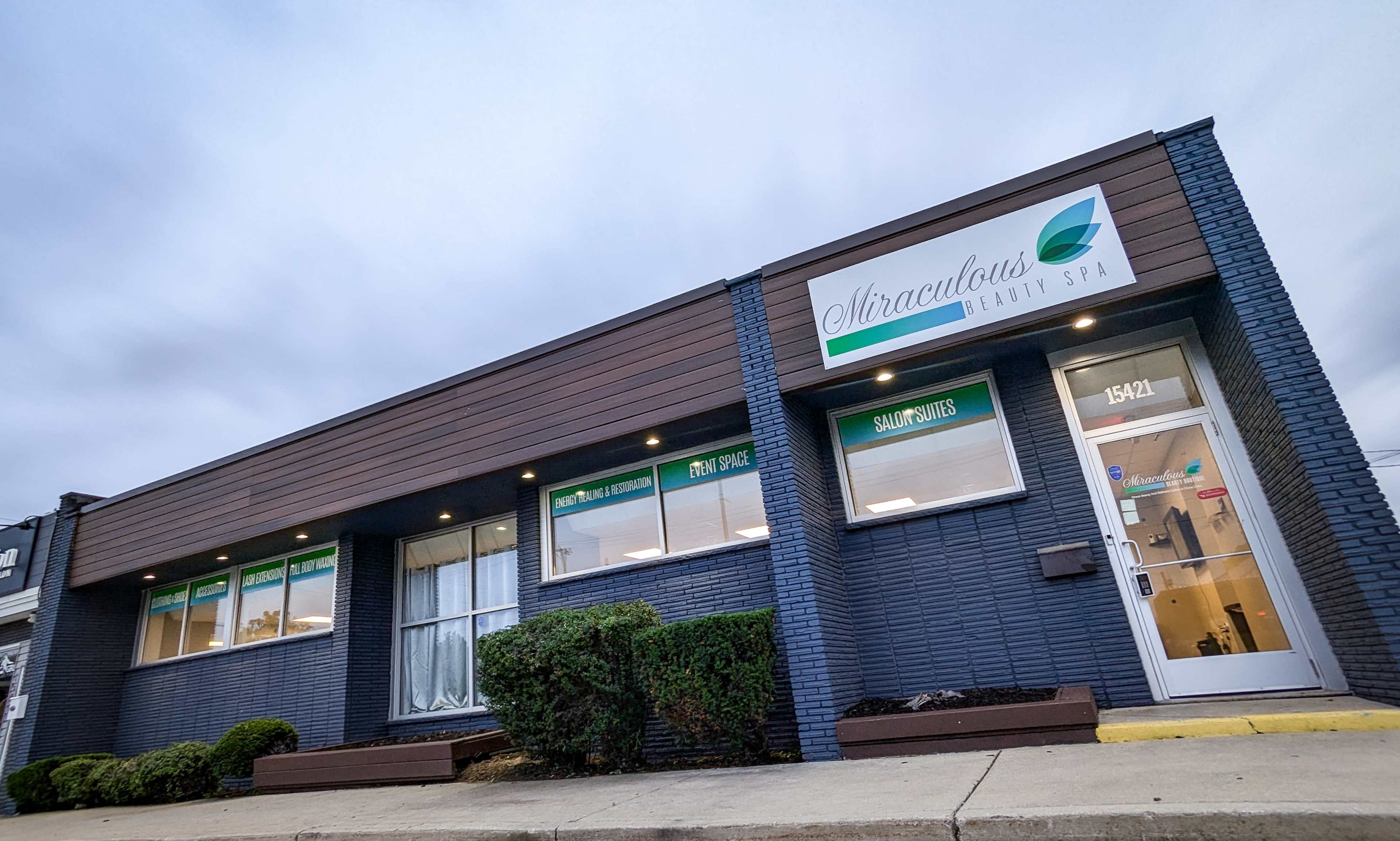 The image shows a modern wellness spa with a brick facade and large windows, displaying the name "Miraculous Wellness Spa" above the entrance.