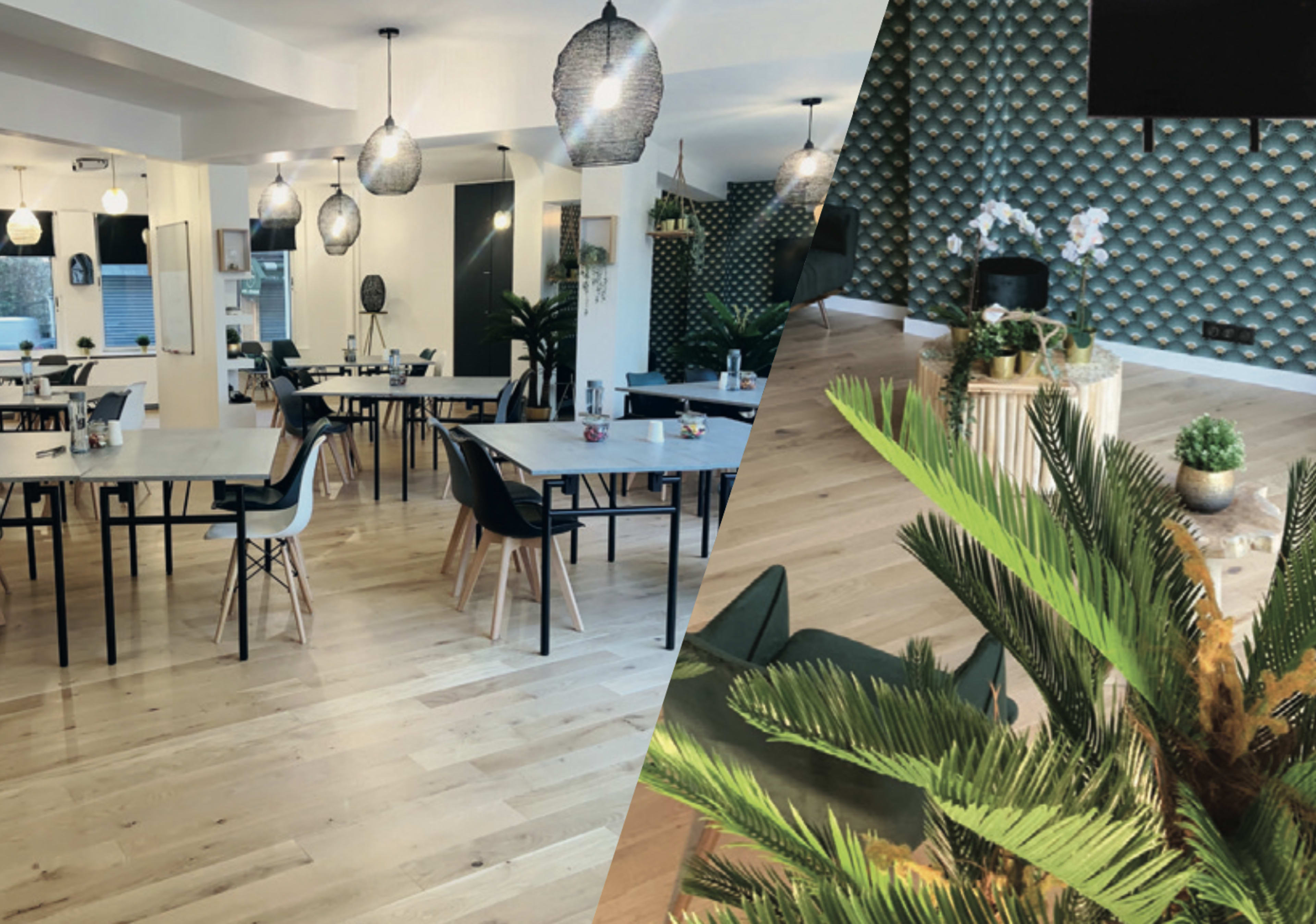 A modern interior of a café or workspace featuring tables, chairs, decorative plants, and pendant lighting.
