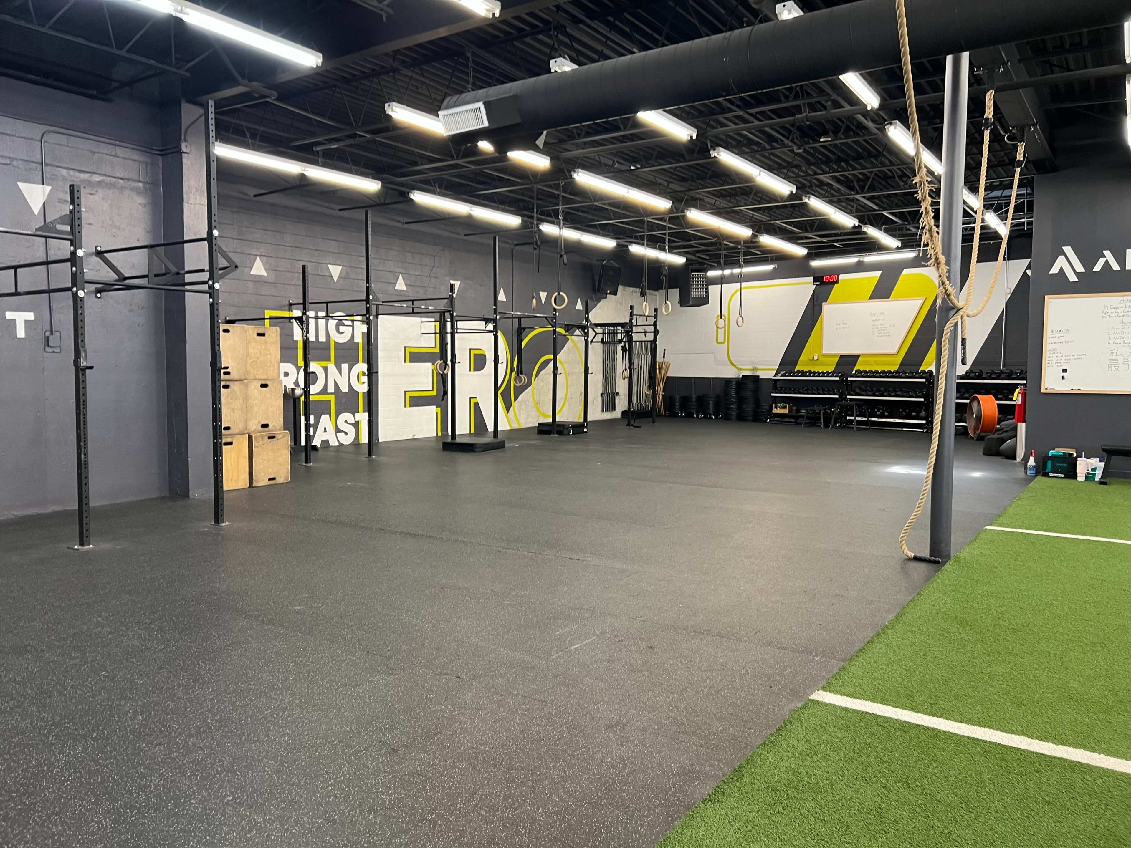 A fitness gym with open floor space, equipped with pull-up bars and various exercise equipment along the walls.