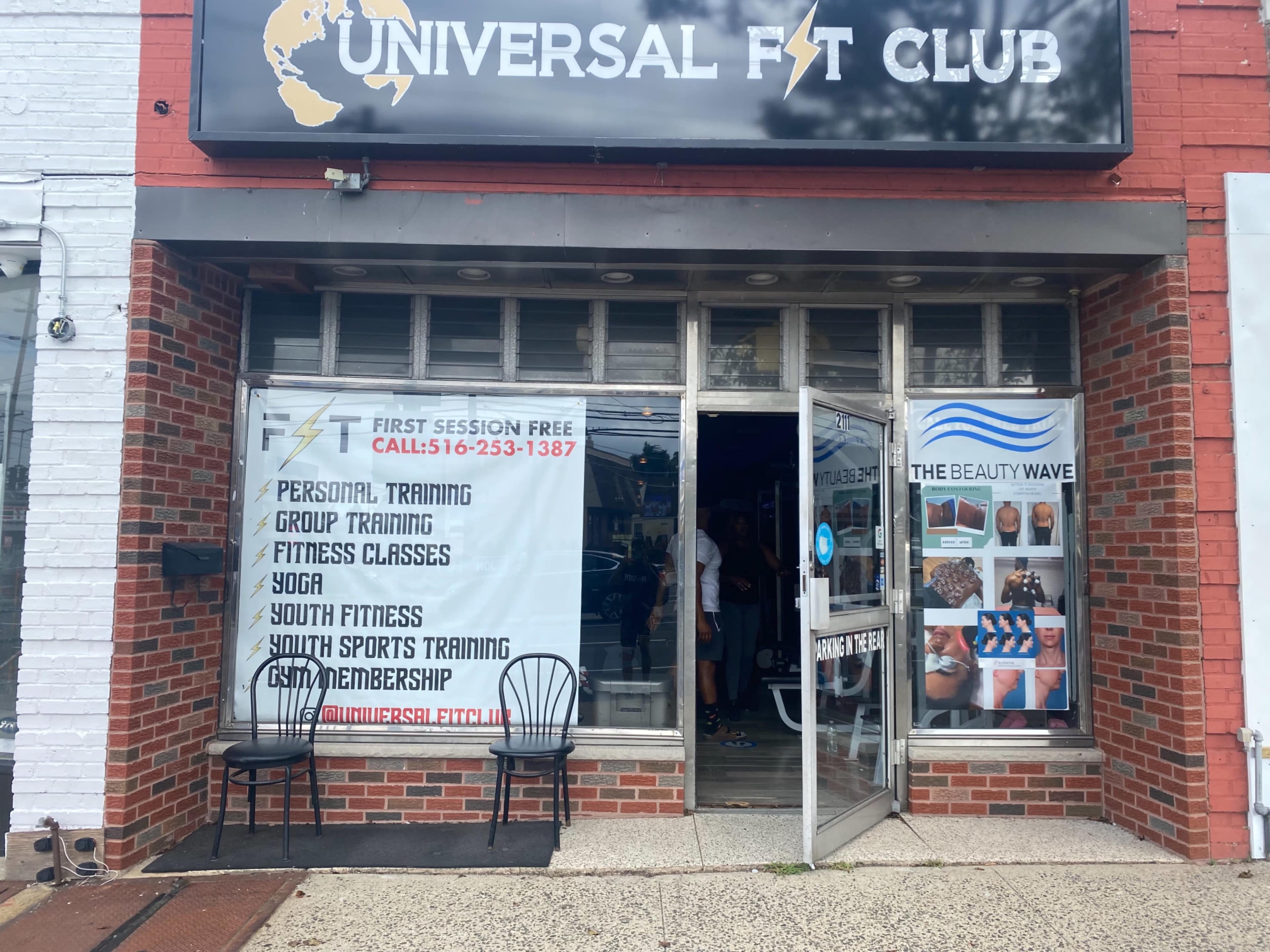 The entrance of Universal Fit Club, featuring a sign with information about various fitness services and classes.