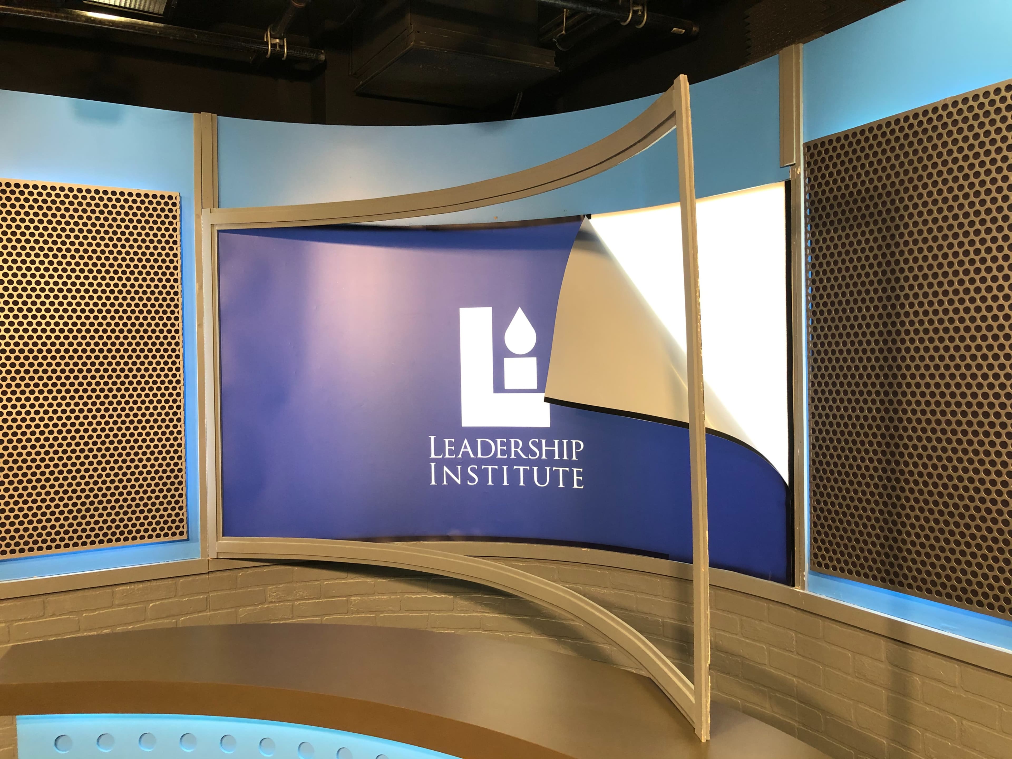 A television studio setup with a backdrop displaying the logo of the Leadership Institute.