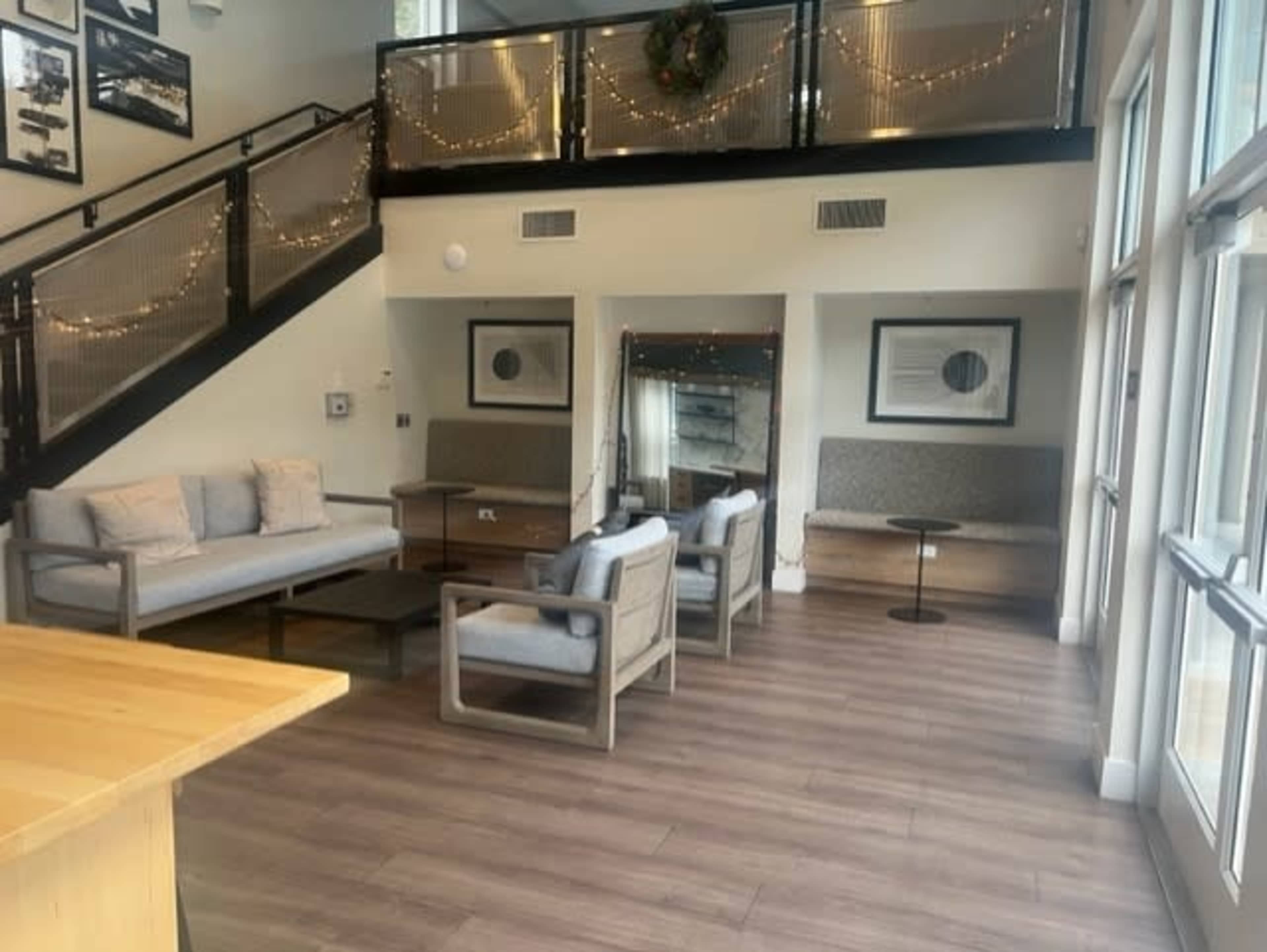 A modern lounge area with seating arrangements, a coffee table, and decorative lighting along the walls.