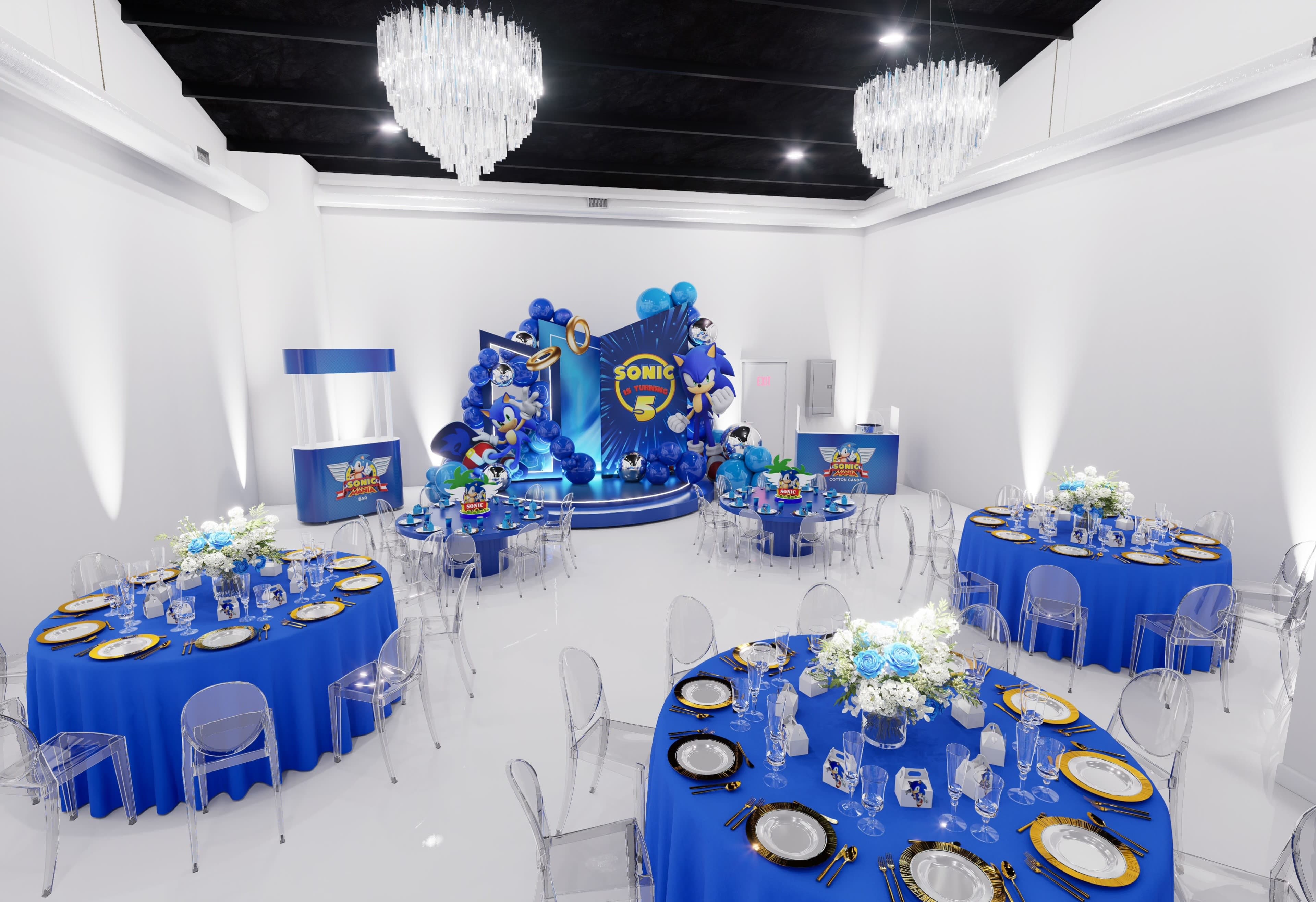 A decorated event space features blue tablecloths, elegant clear chairs, and a backdrop with blue balloons, set for a Sonic the Hedgehog-themed celebration.