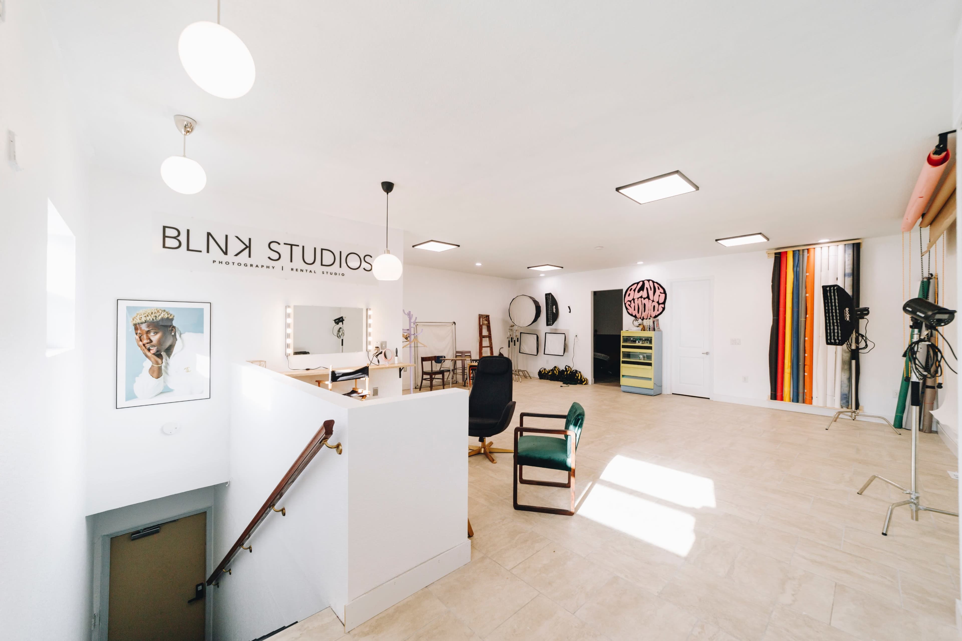 The interior of BLNK Studios features a modern photography workspace with a reception area and various backdrops.