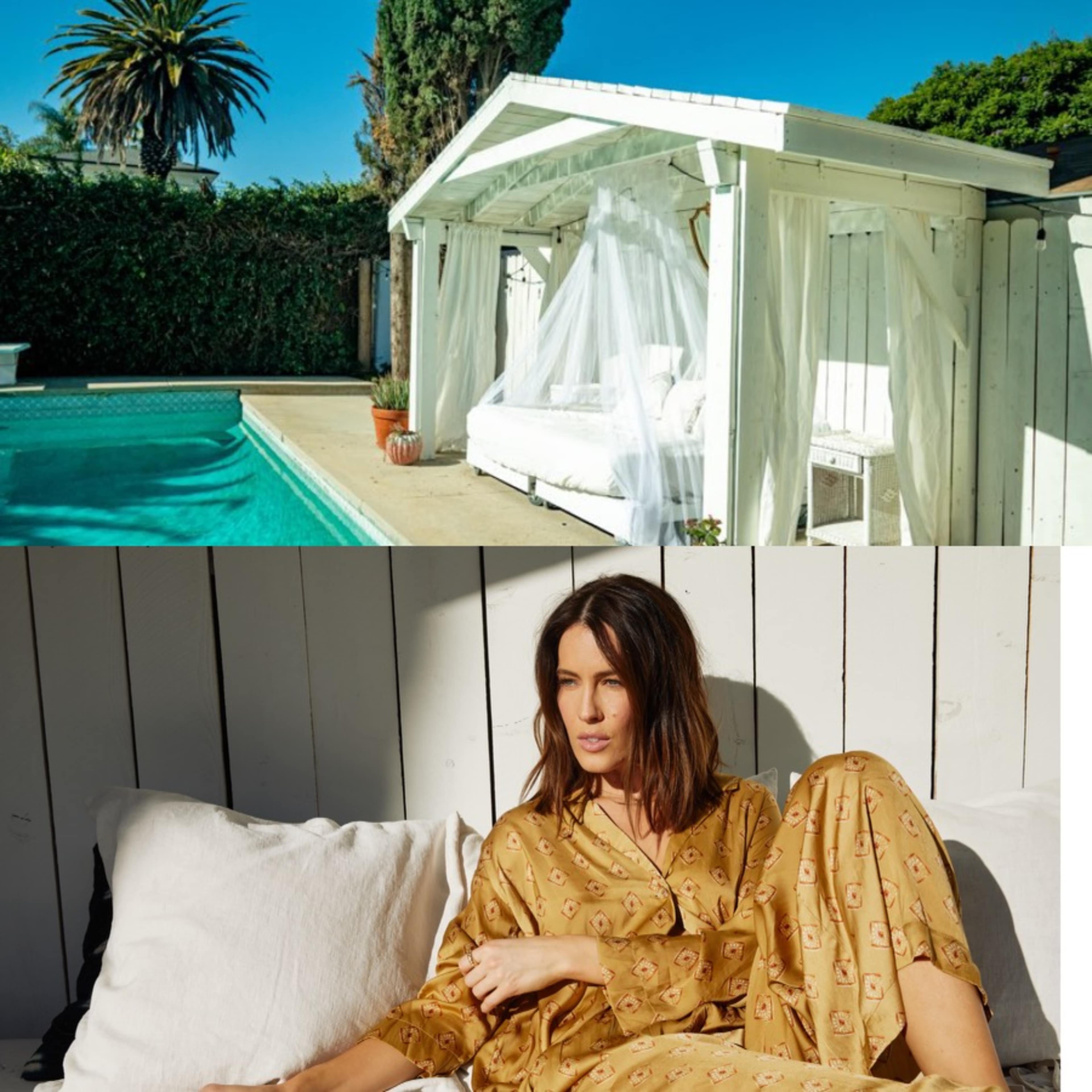 A woman in a patterned outfit relaxes on a white couch under a canopy next to a pool.