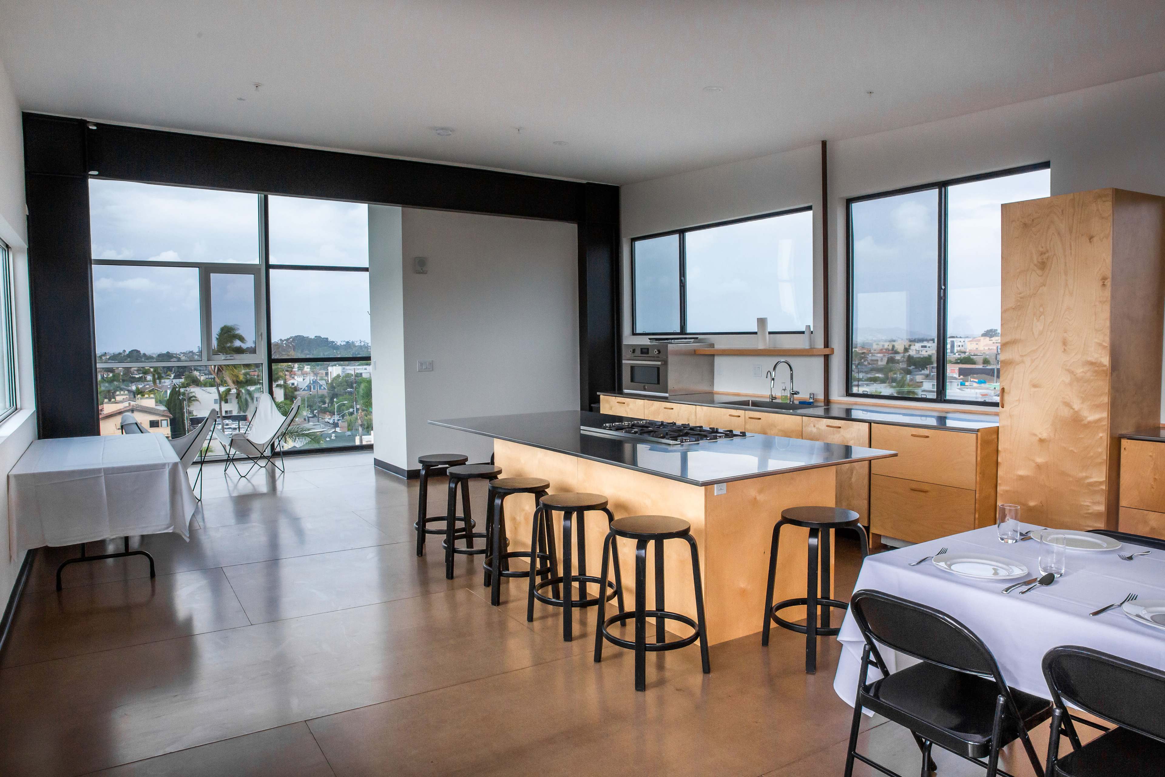 A modern kitchen and dining area with large windows overlooking a cityscape.