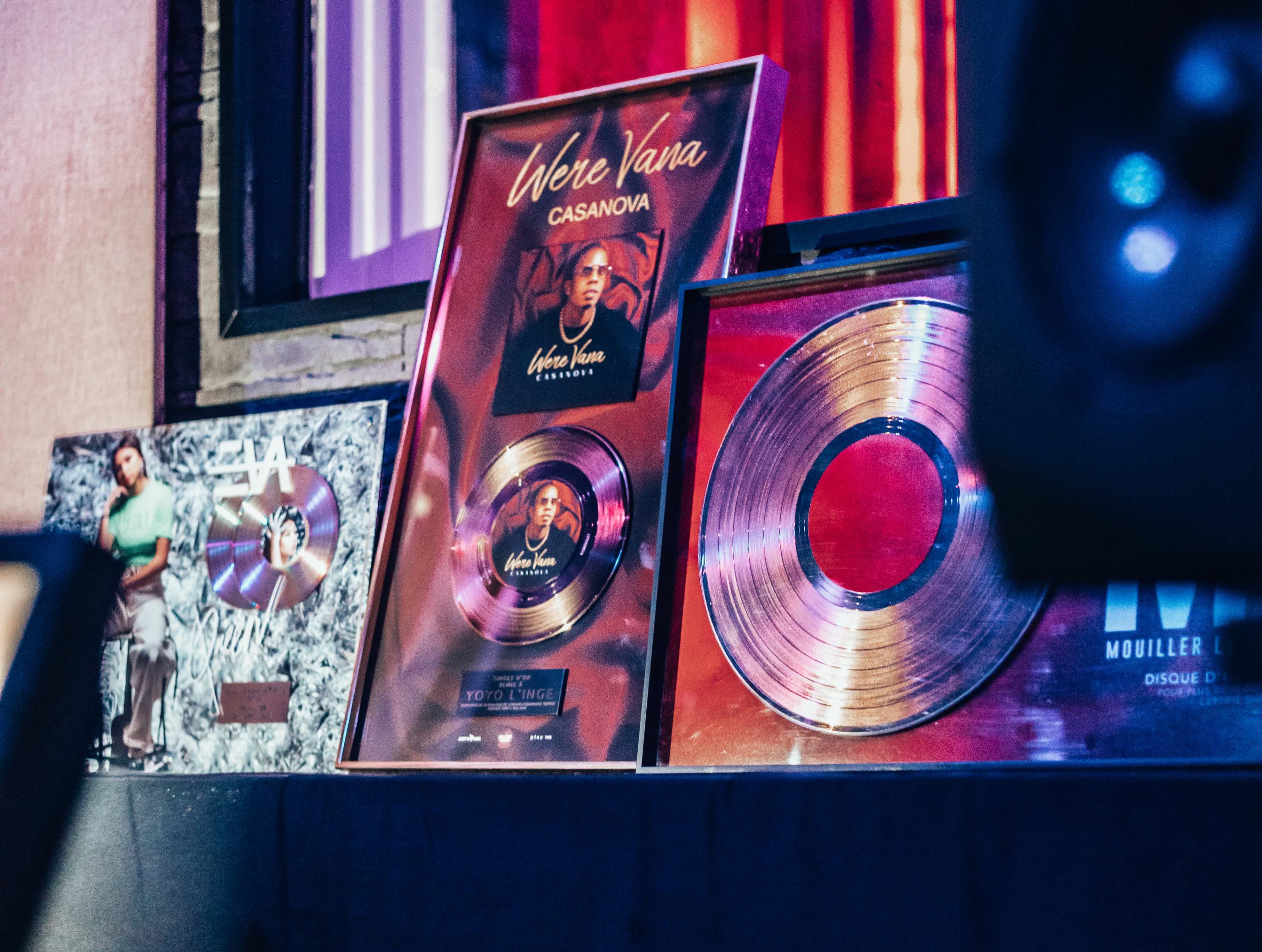 Several music awards, including gold records and framed achievements, arranged on a table.