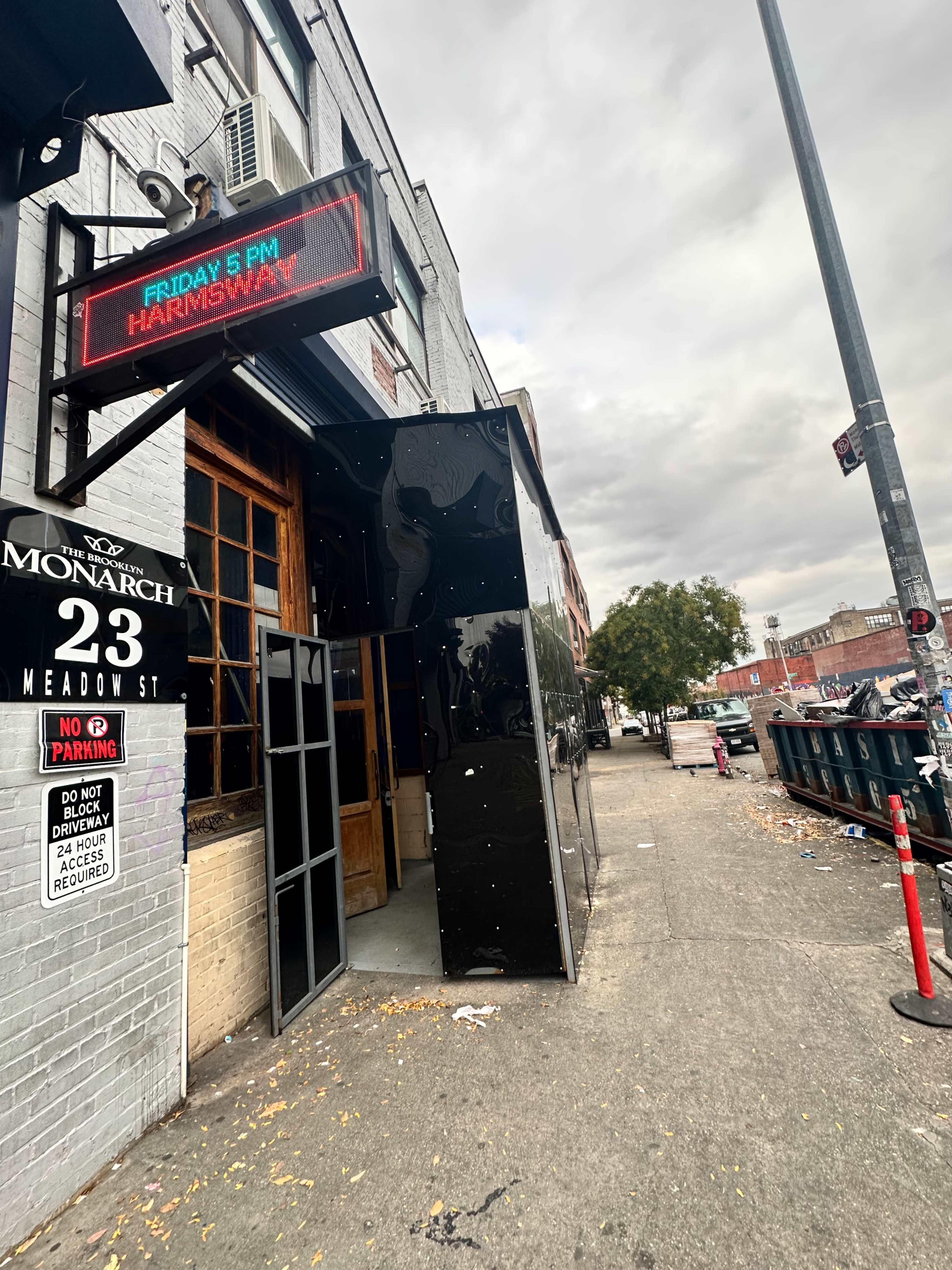 The entrance of a building named "Monarch" is visible on Meadow Street, featuring a large digital sign displaying an event for "Harmsway" on Friday at 5 PM.