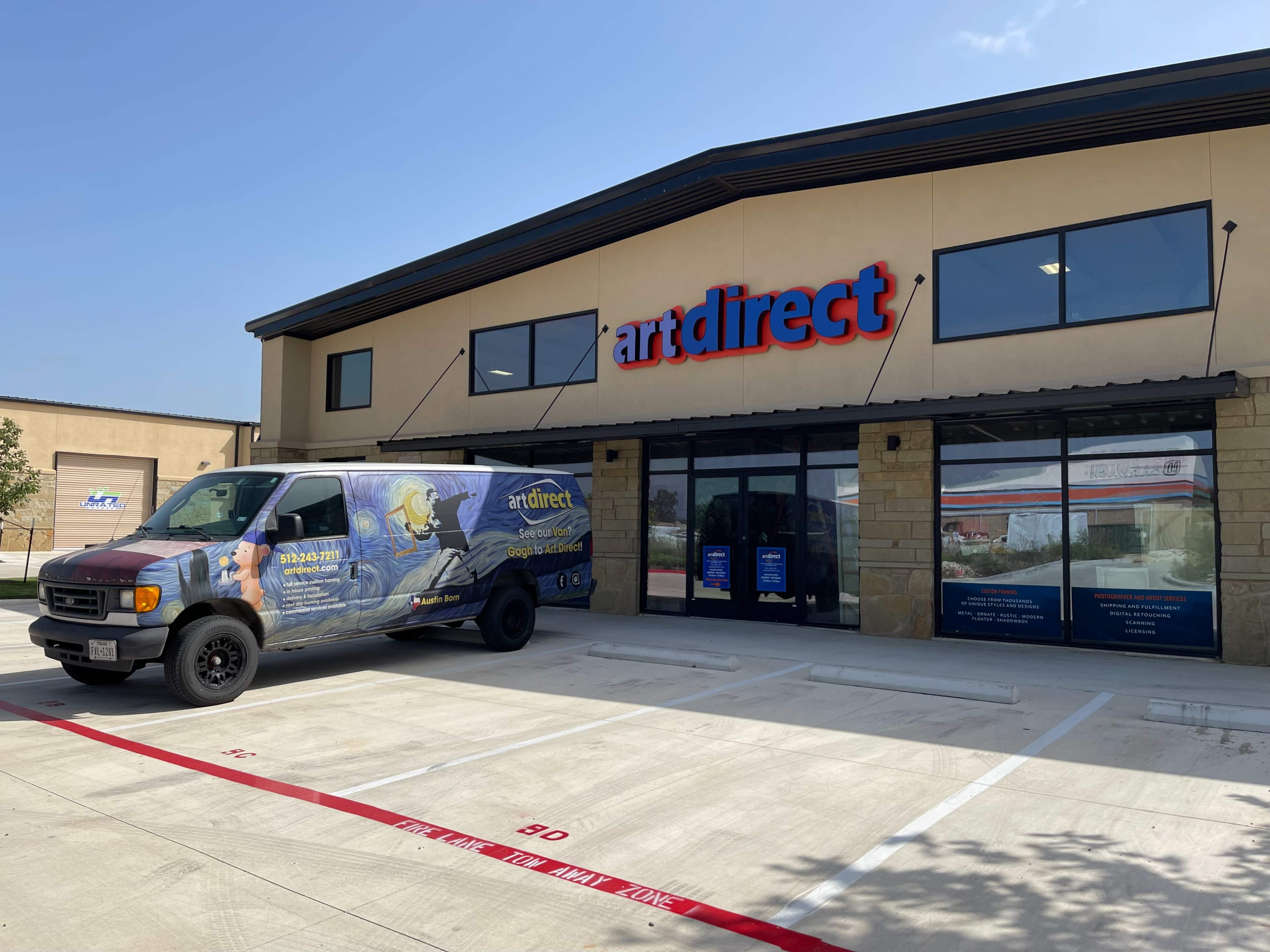 A delivery van is parked in front of a building with the signs "artdirect" and "art supplies" displayed prominently.