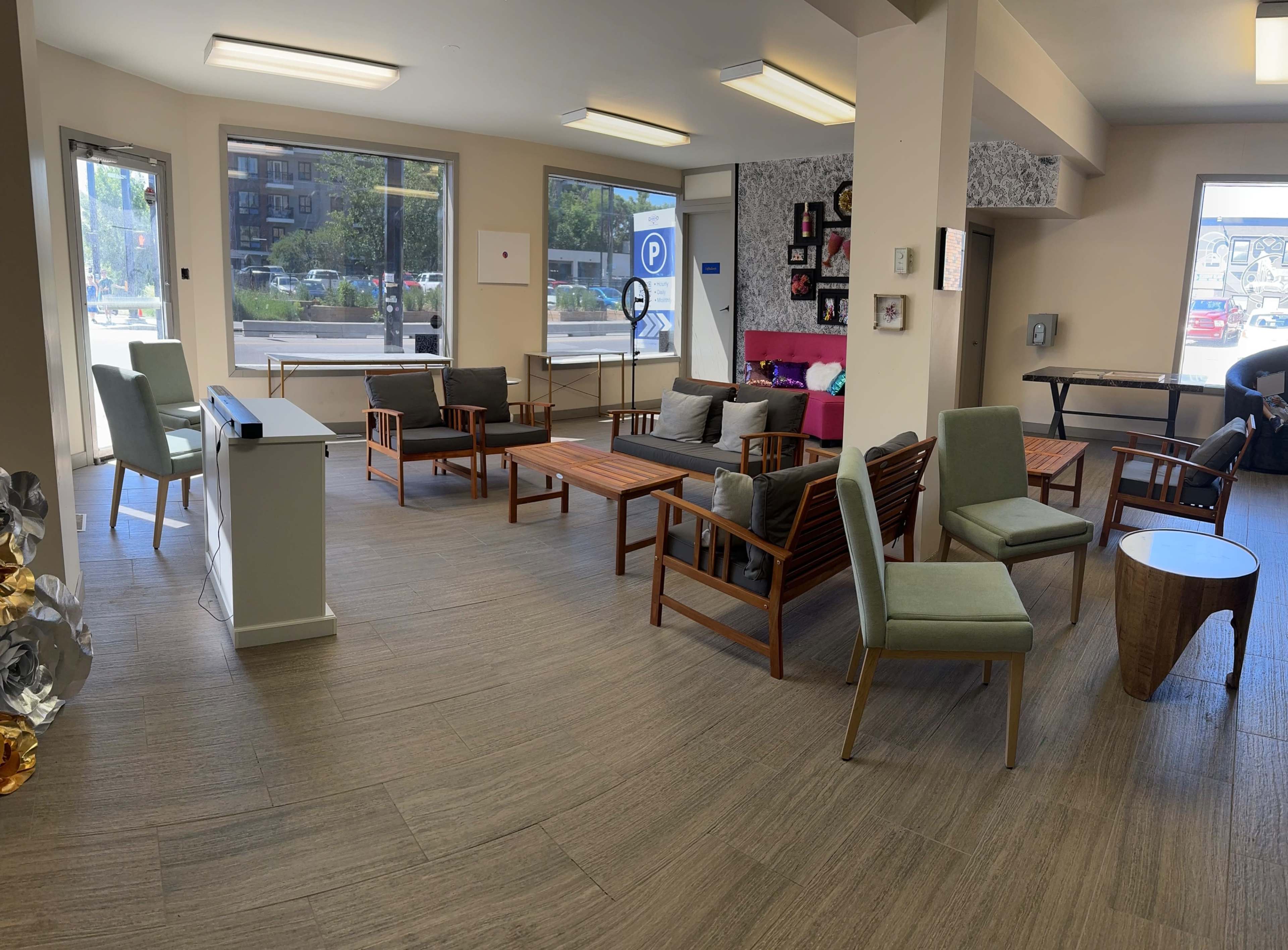 A spacious lounge area with wooden furniture, large windows, and a bright interior design.