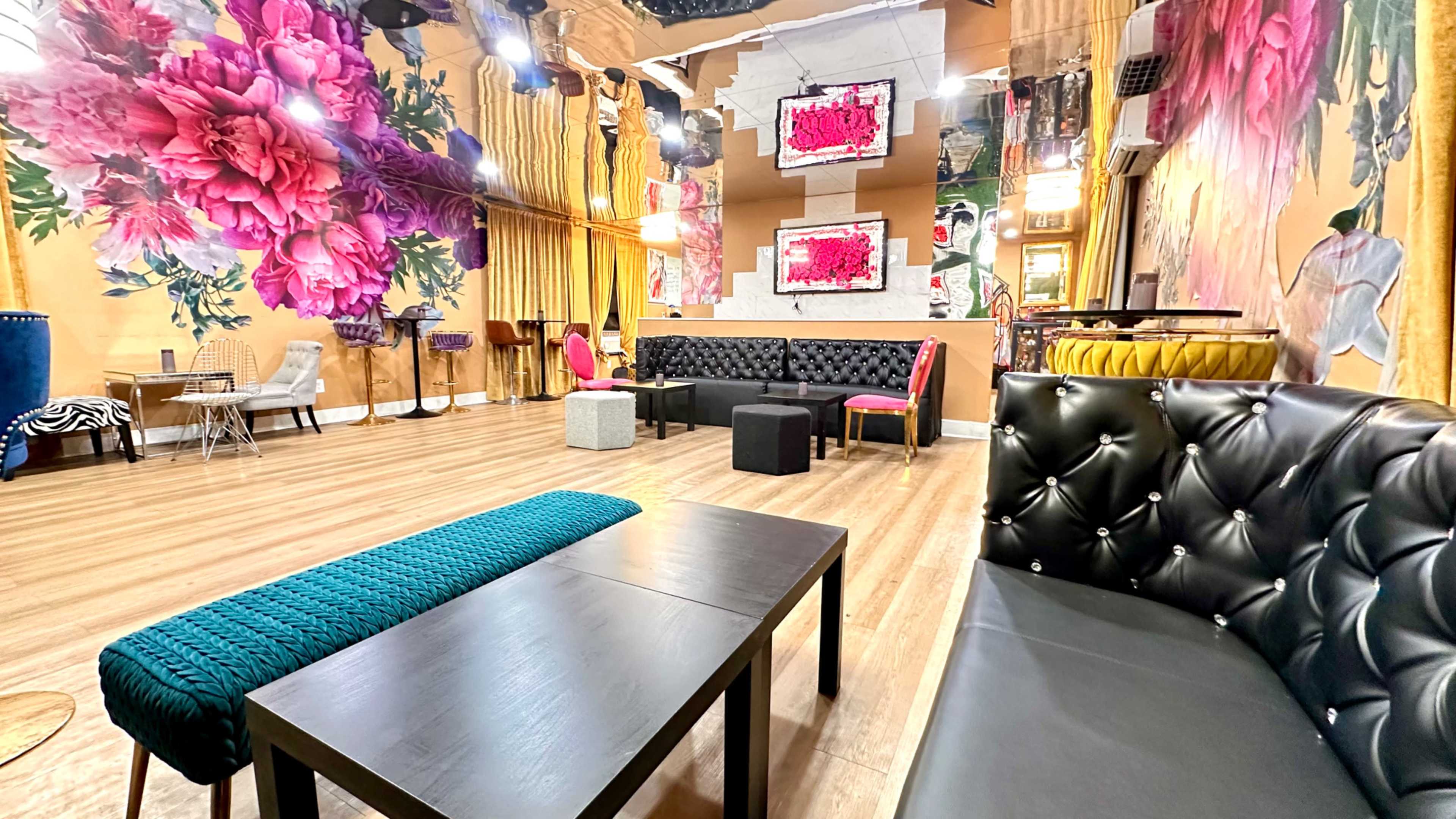 The interior of a lounge features colorful floral wall art, elegant seating arrangements, and modern lighting fixtures.