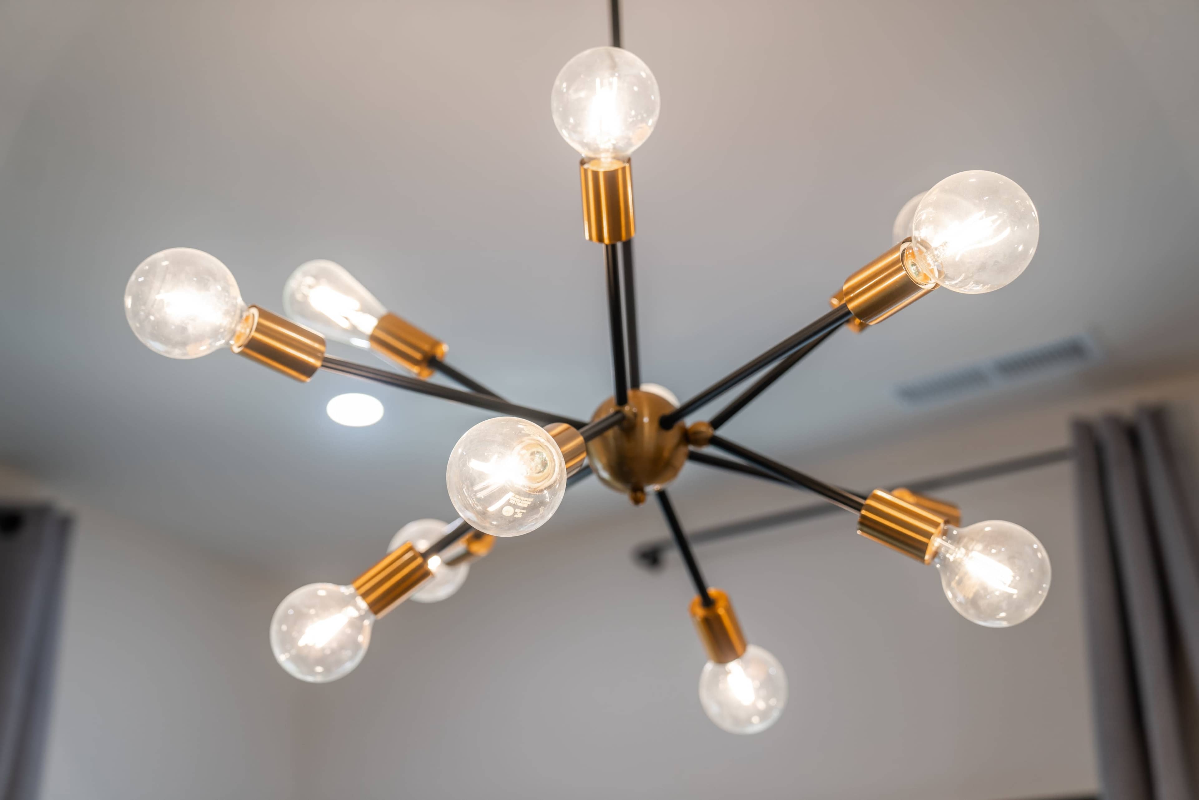 A modern chandelier with multiple light bulbs arranged in a star-shaped design.
