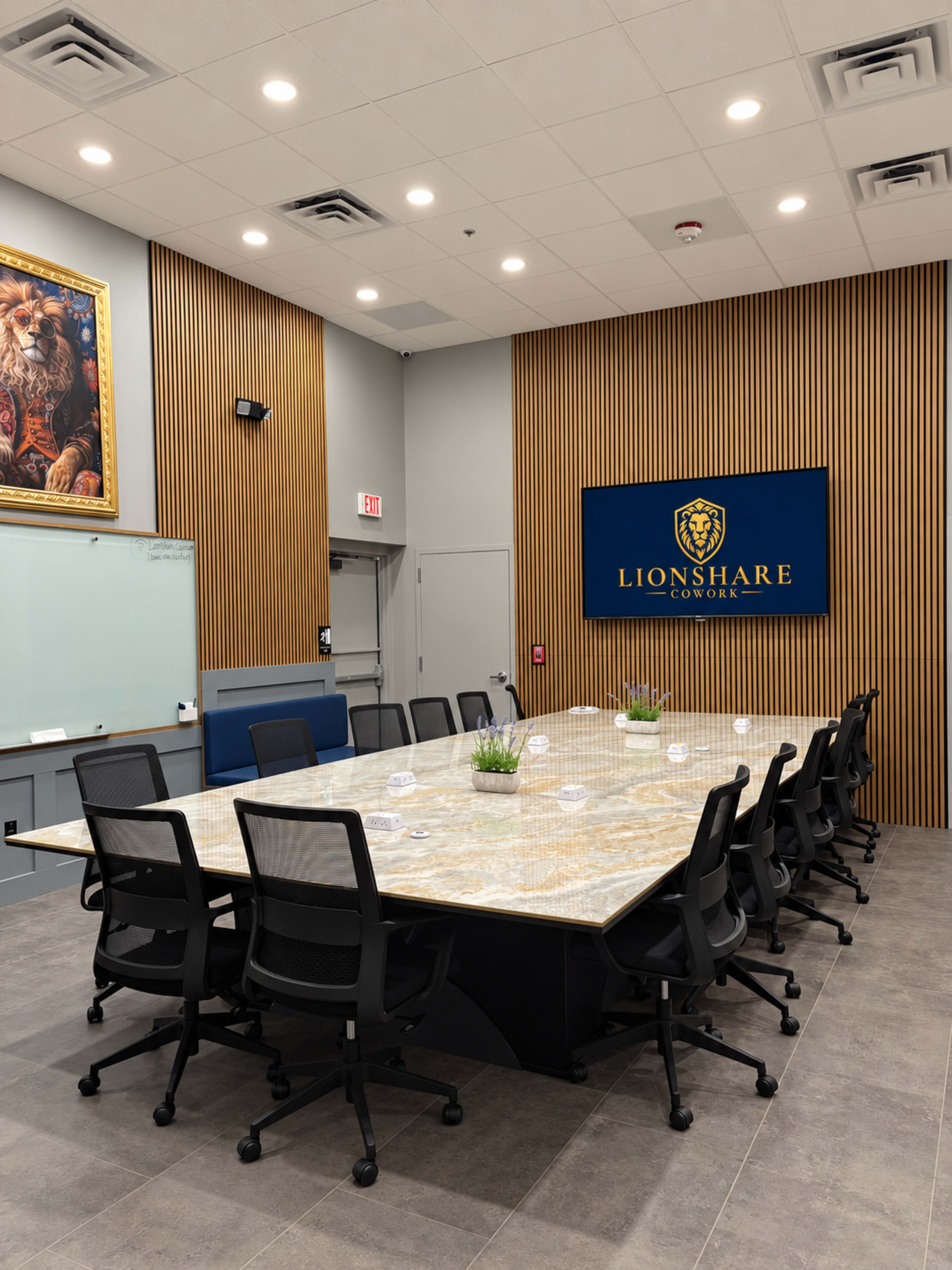 The image shows a modern conference room featuring a large rectangular table surrounded by black ergonomic chairs, with wooden paneling on the walls and a prominently displayed logo for "LIONSHARE COWORK."