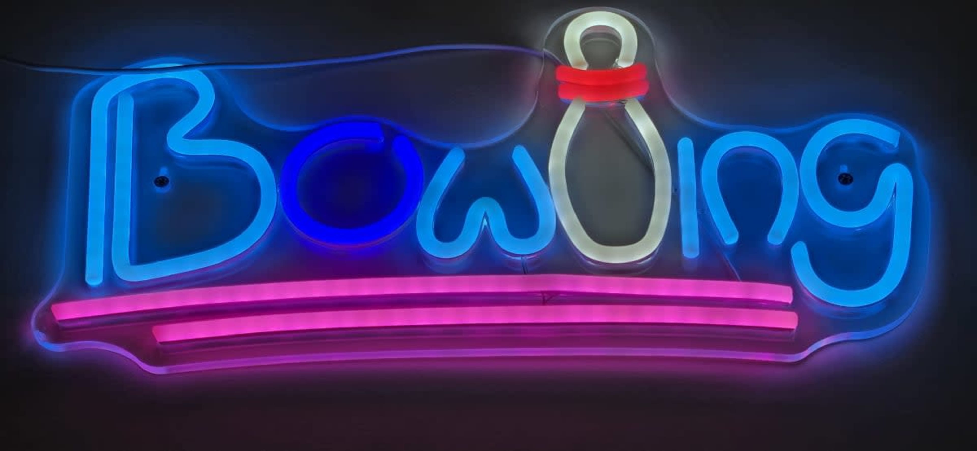 A brightly lit neon sign displays the word "Bowling" in colorful letters with a bowling pin illustration.