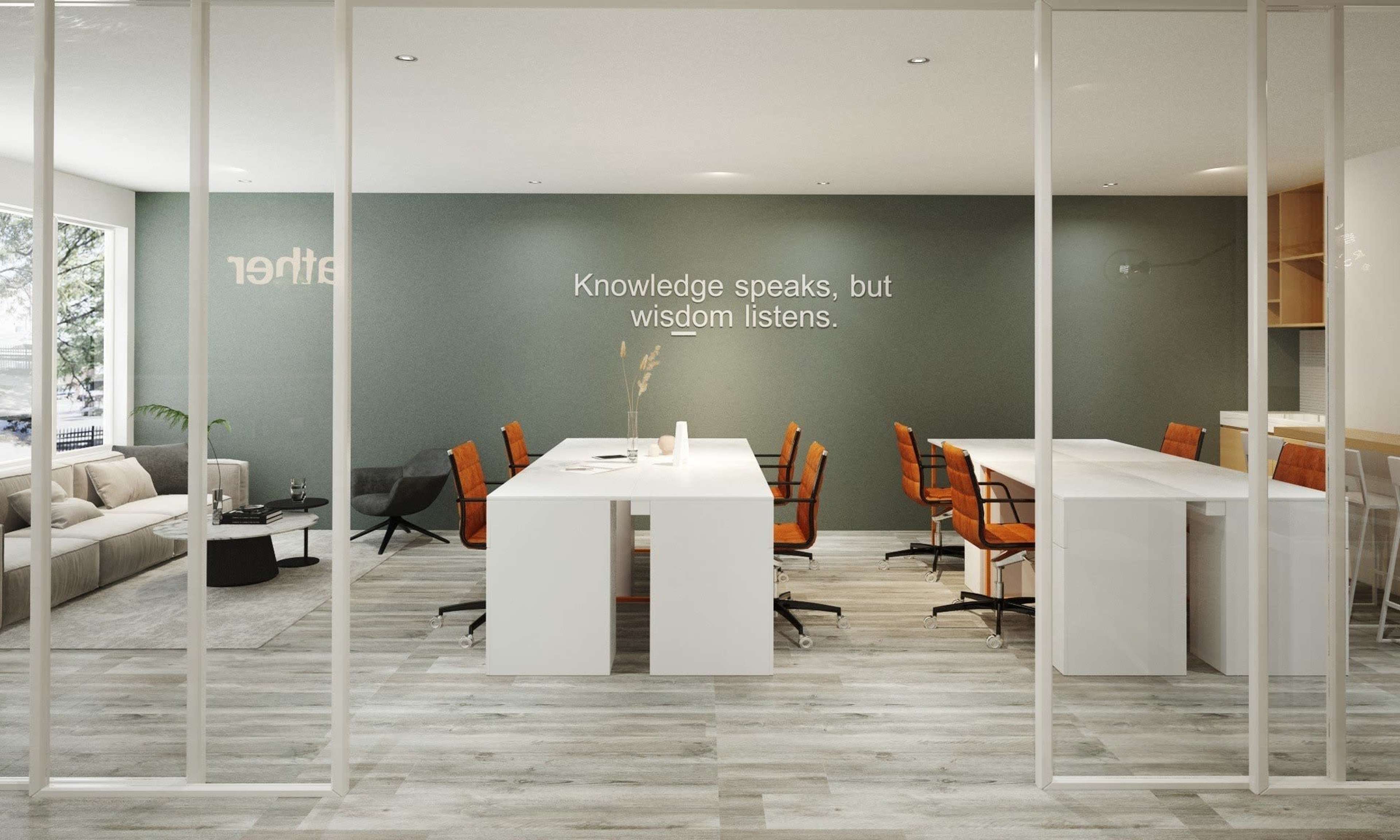 A modern office space featuring a row of white work desks with orange office chairs, a sofa area, and a wall with a quote about knowledge and wisdom.