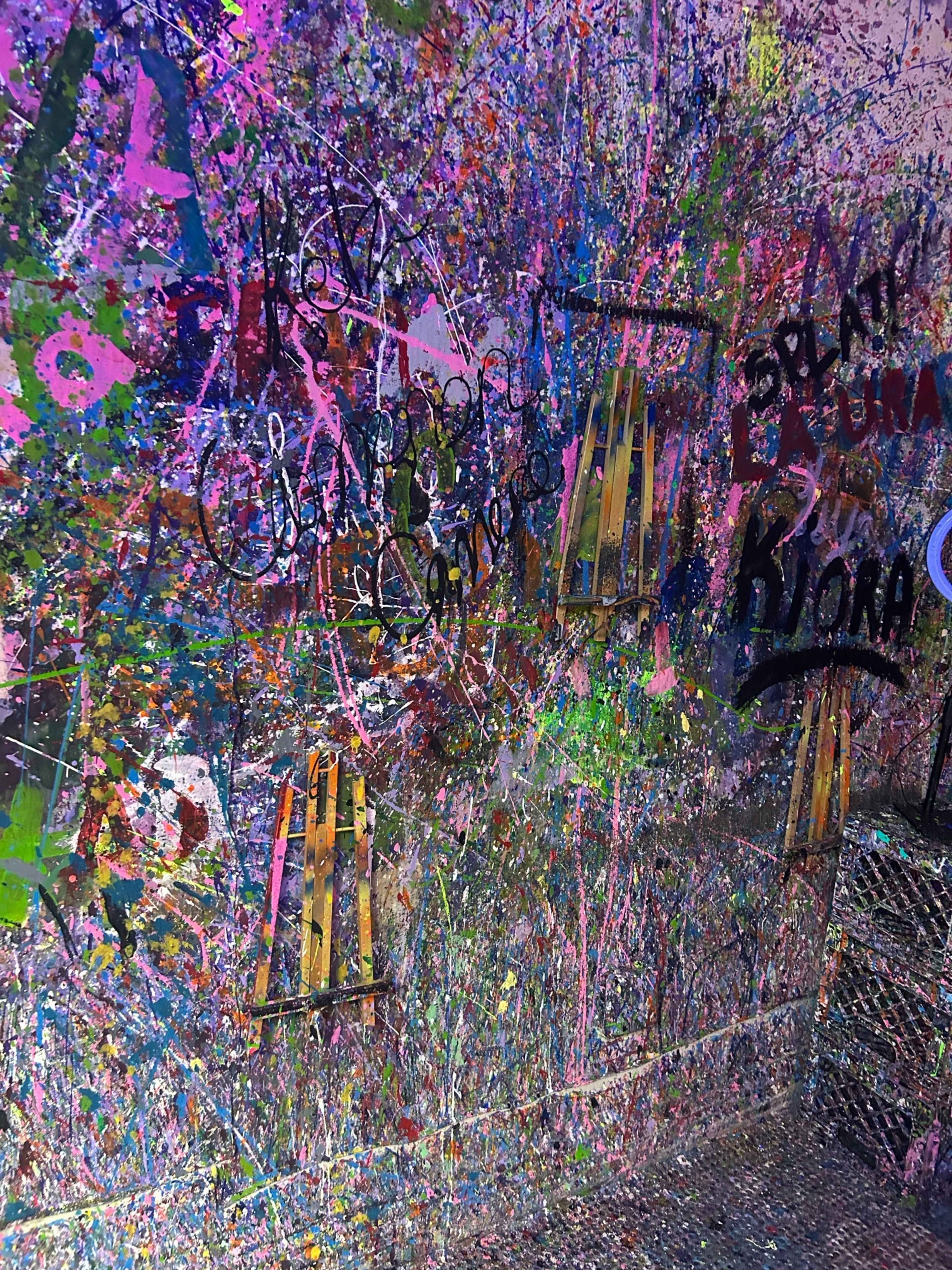 The wall is covered in a chaotic array of colorful paint splatters and graffiti tags.