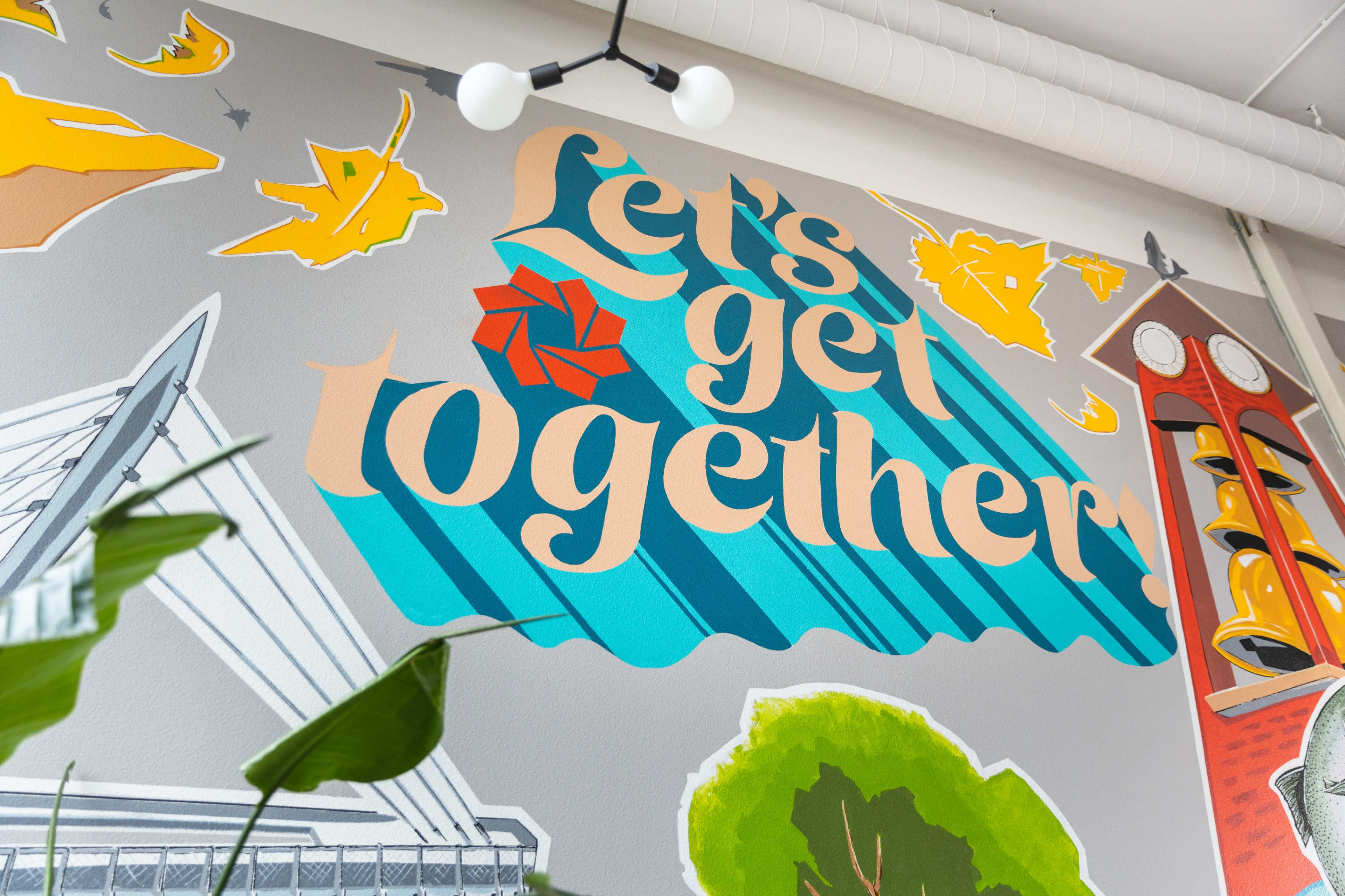 A vibrant mural featuring the phrase "Let's get together," surrounded by colorful illustrations and geometric shapes.