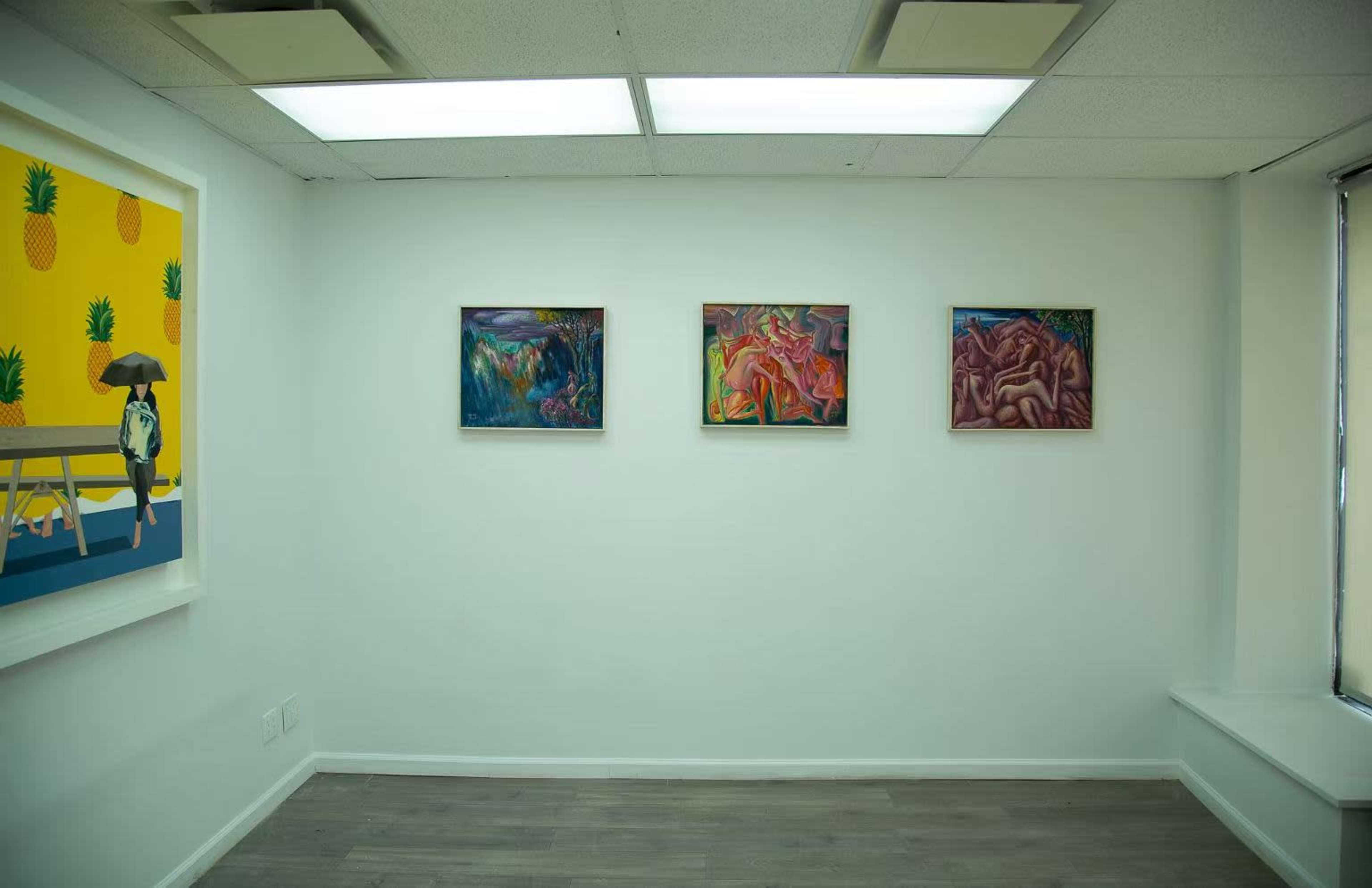 The image shows a minimalist art gallery with four framed paintings displayed on a white wall.
