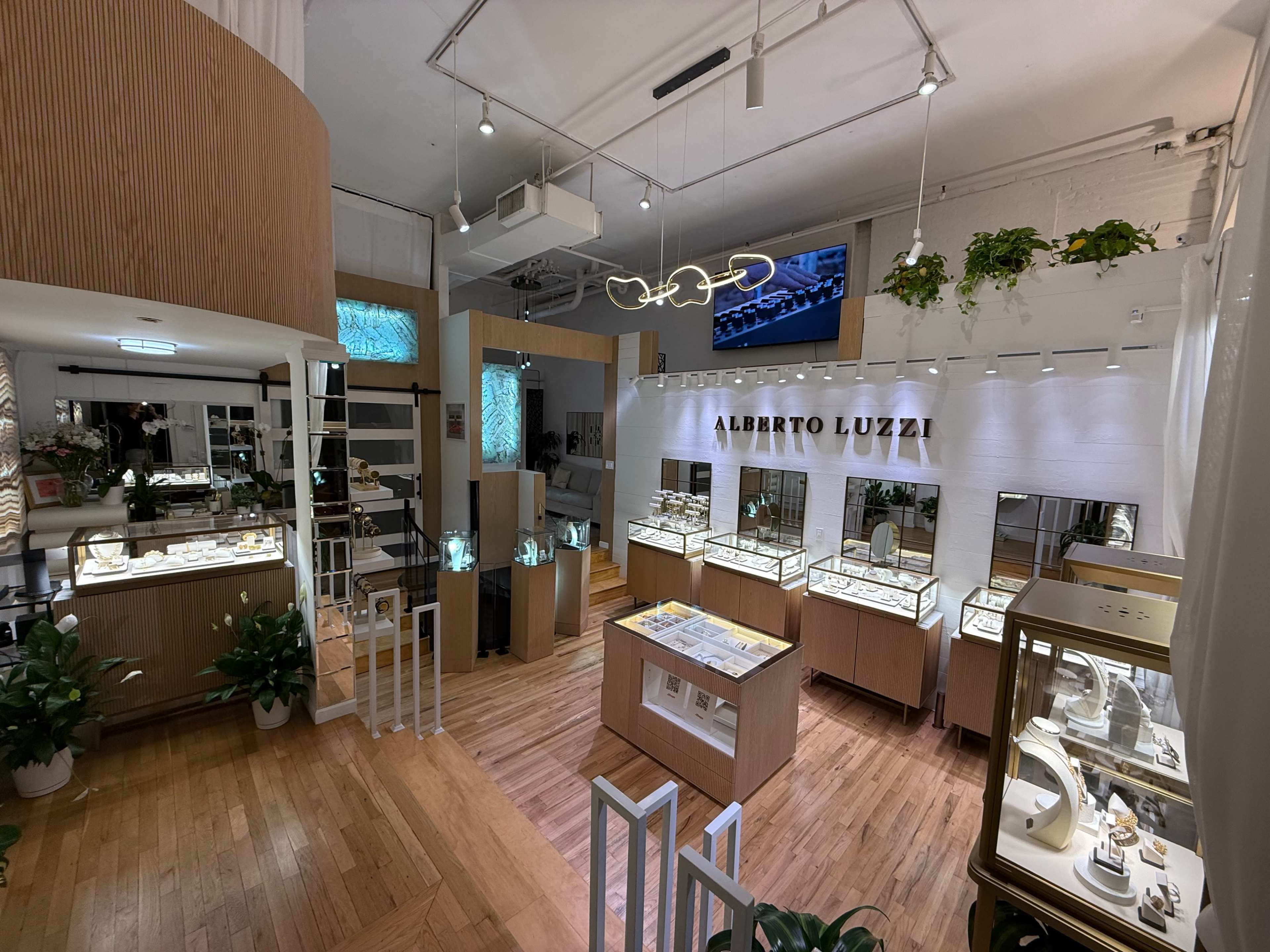 The image shows a jewelry shop interior featuring display cases filled with various pieces of jewelry, wooden decor, and a modern layout.
