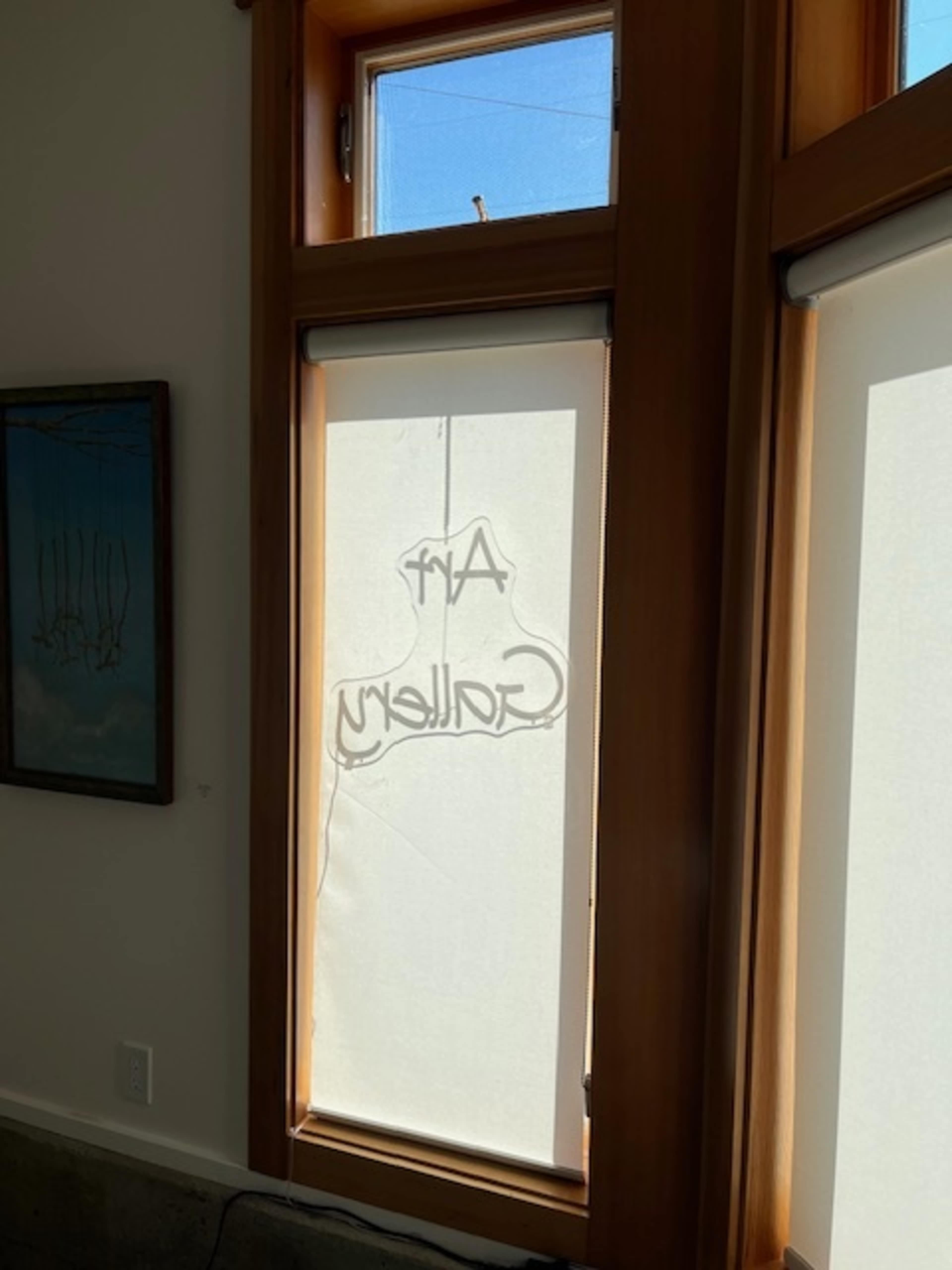 A translucent shade in a window displays the words "Art Gallery" in shadow.