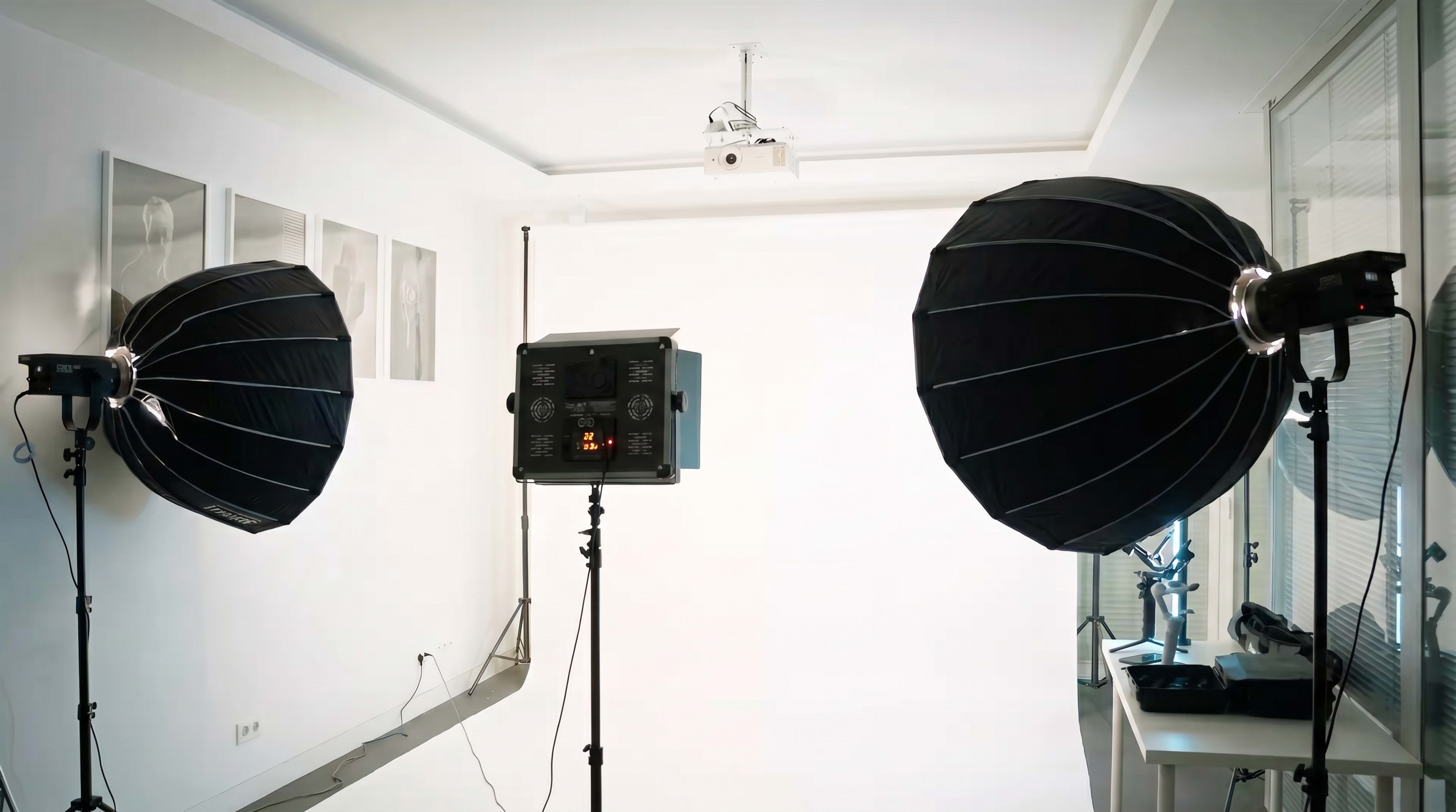 The image shows a photo studio setup with two large softbox lights positioned on either side of a blank backdrop.