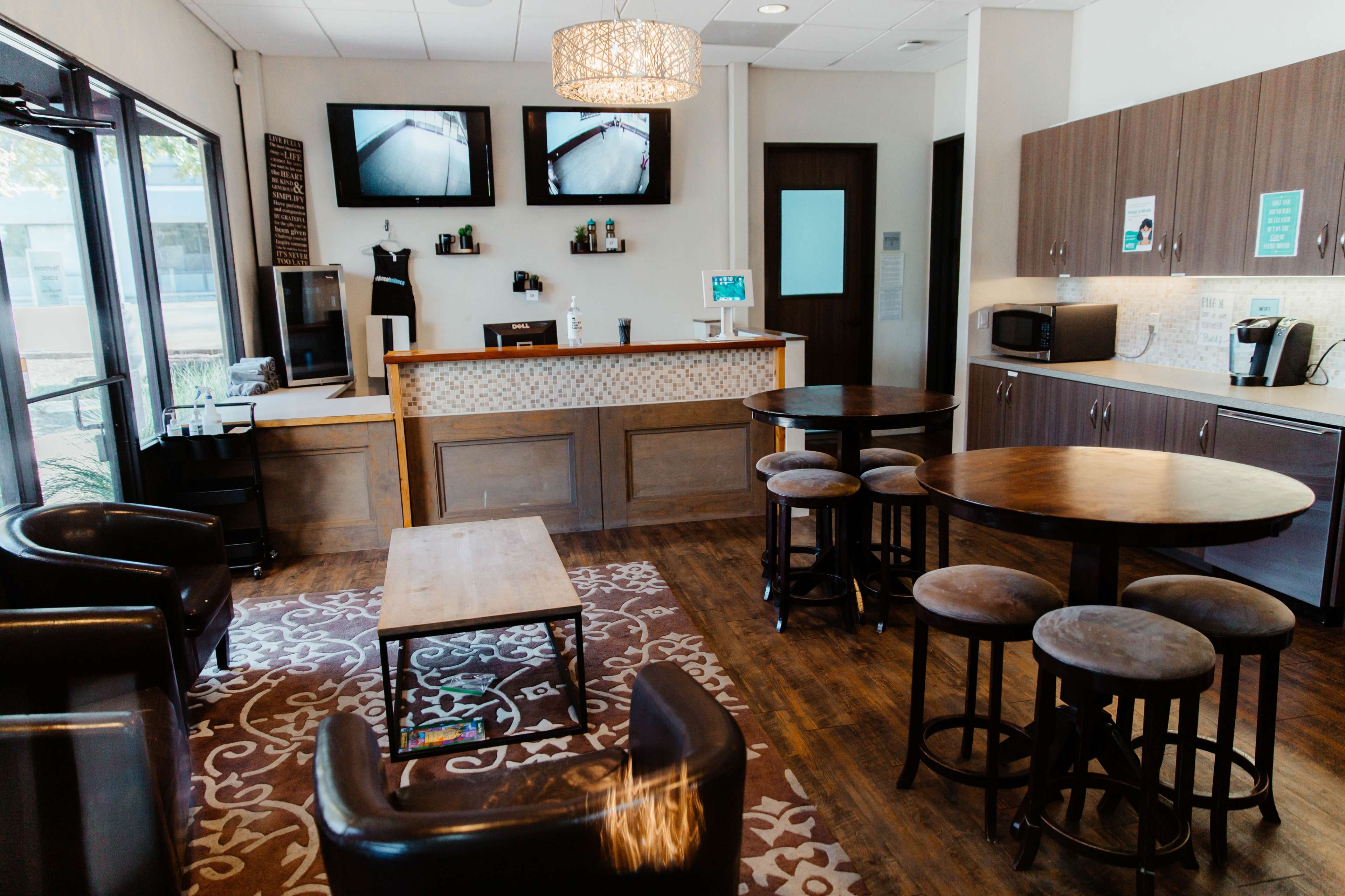 The image shows a modern reception area with a front desk, seating arrangements, and a coffee station.