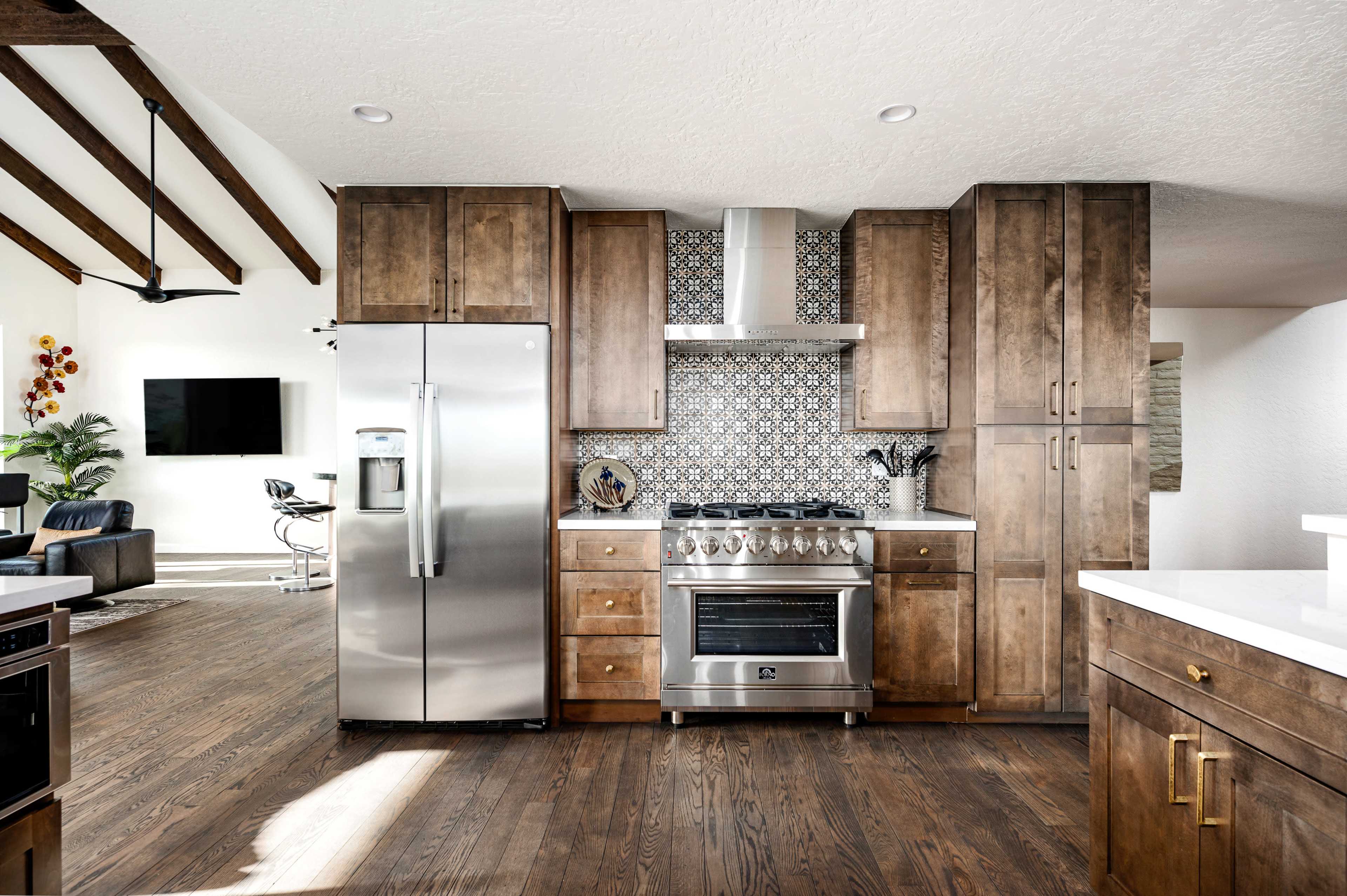 A modern kitchen featuring wooden cabinetry, stainless steel appliances, and a patterned tile backsplash.