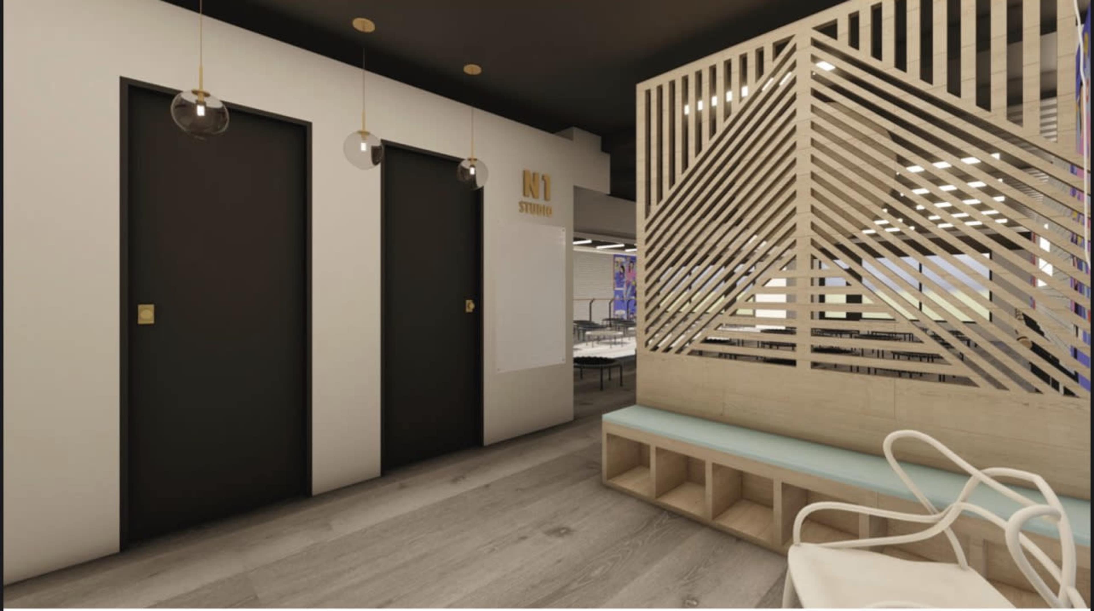 The image shows a modern interior space with two black doors, a wooden partition with diagonal slats, and a light blue seating area.