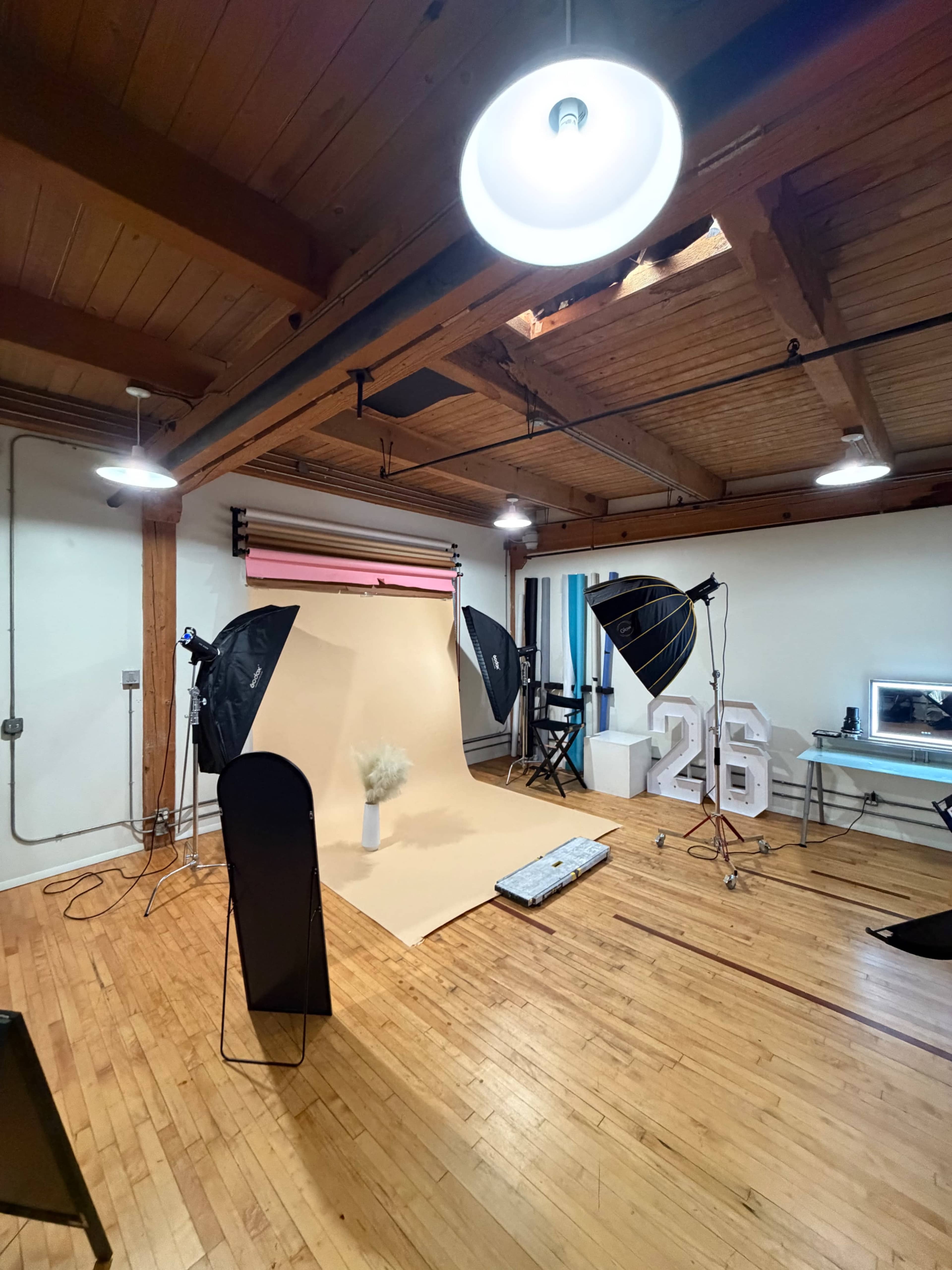 A photography studio features a backdrop, lighting equipment, and props arranged for a photoshoot.