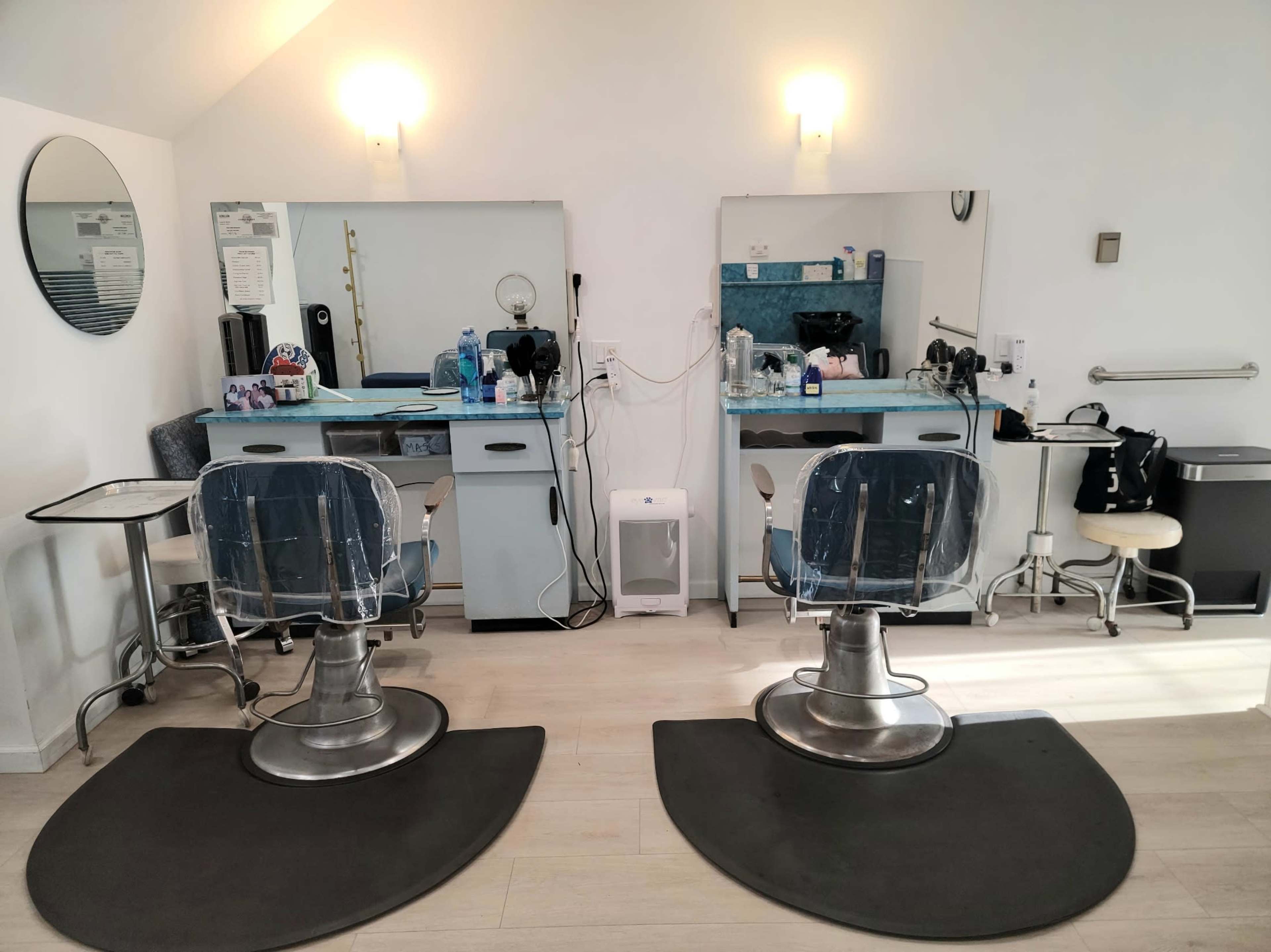 A tidy hair salon with two styling chairs, mirrors, and various hair care products on the countertops.
