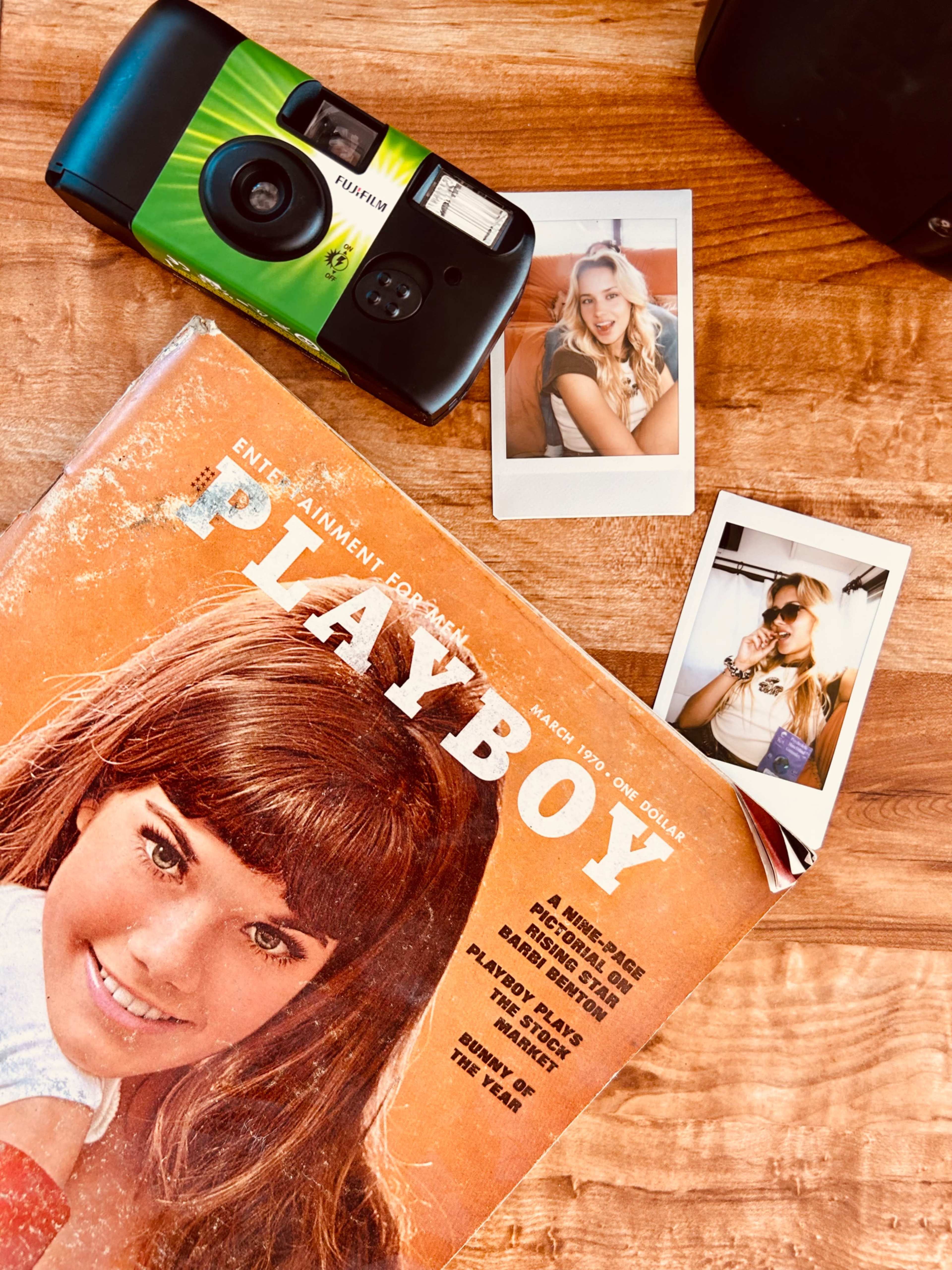 A vintage Playboy magazine, a point-and-shoot camera, and two Polaroid photos of a woman.