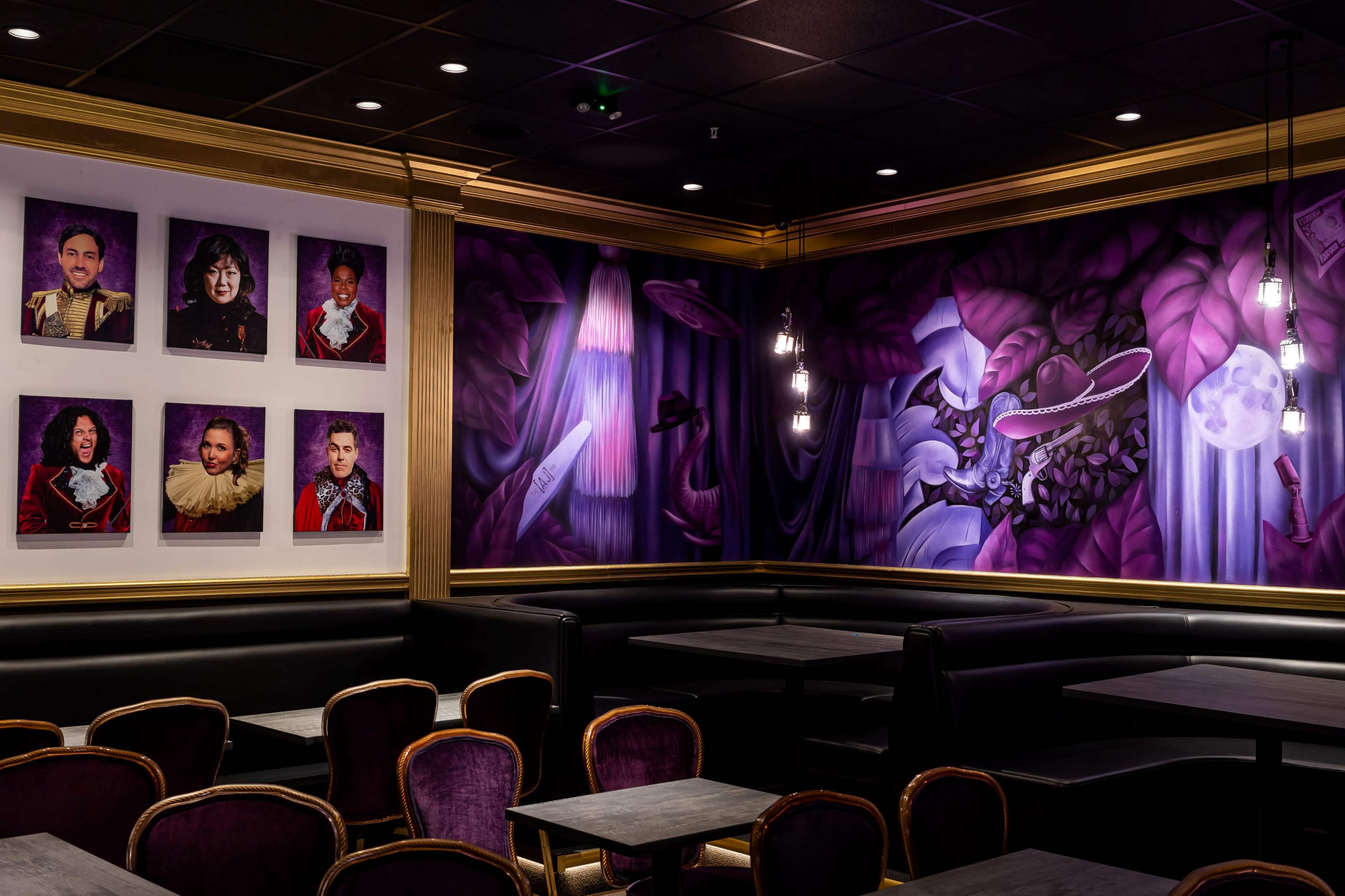 The image shows a corner of a restaurant featuring a mural with various portraits, purple tones, and a seating area with dark tables and chairs.