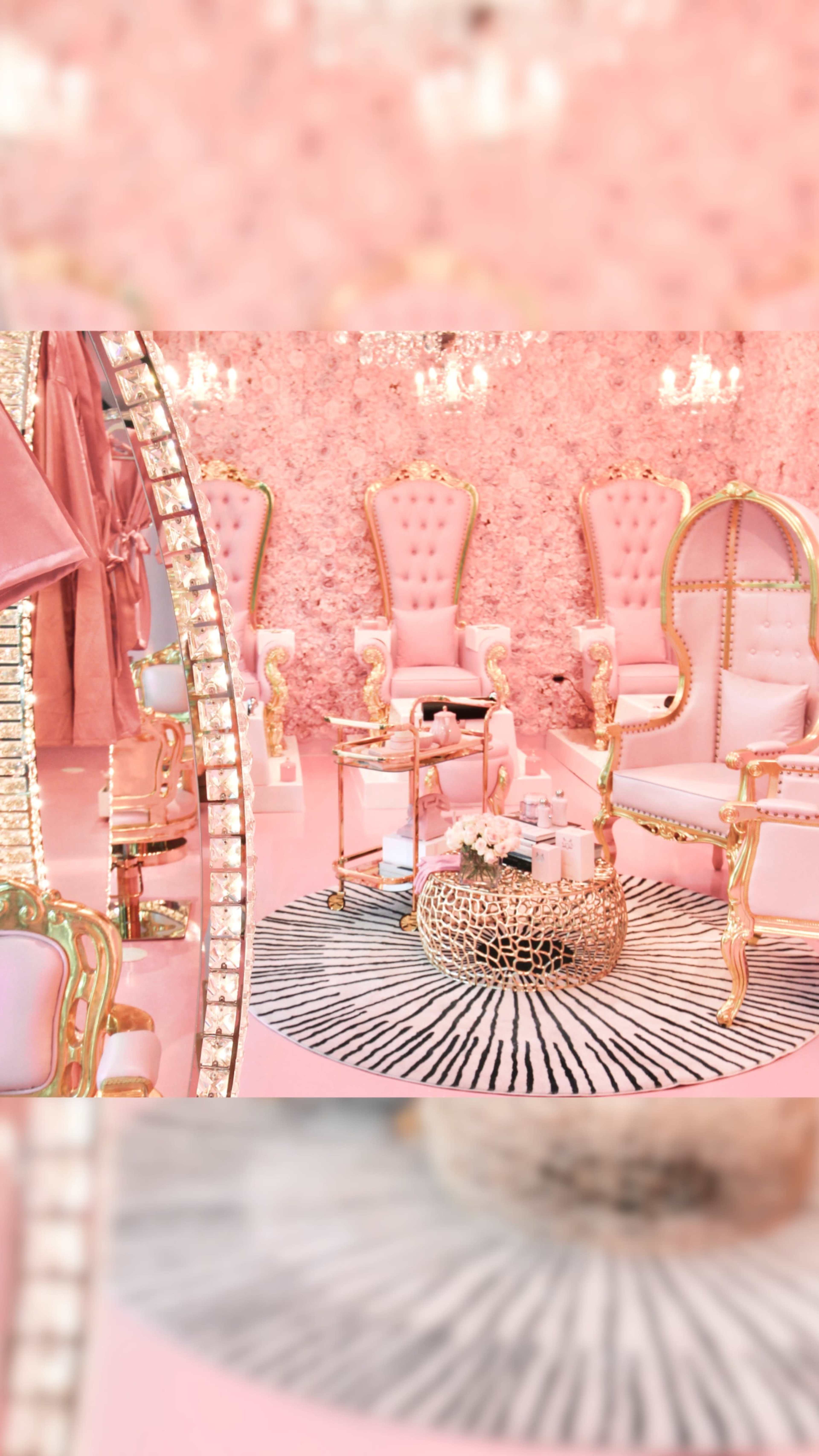 The image depicts a lavish interior with pink walls adorned with flowers, featuring elegant golden-accented furniture and a round rug.
