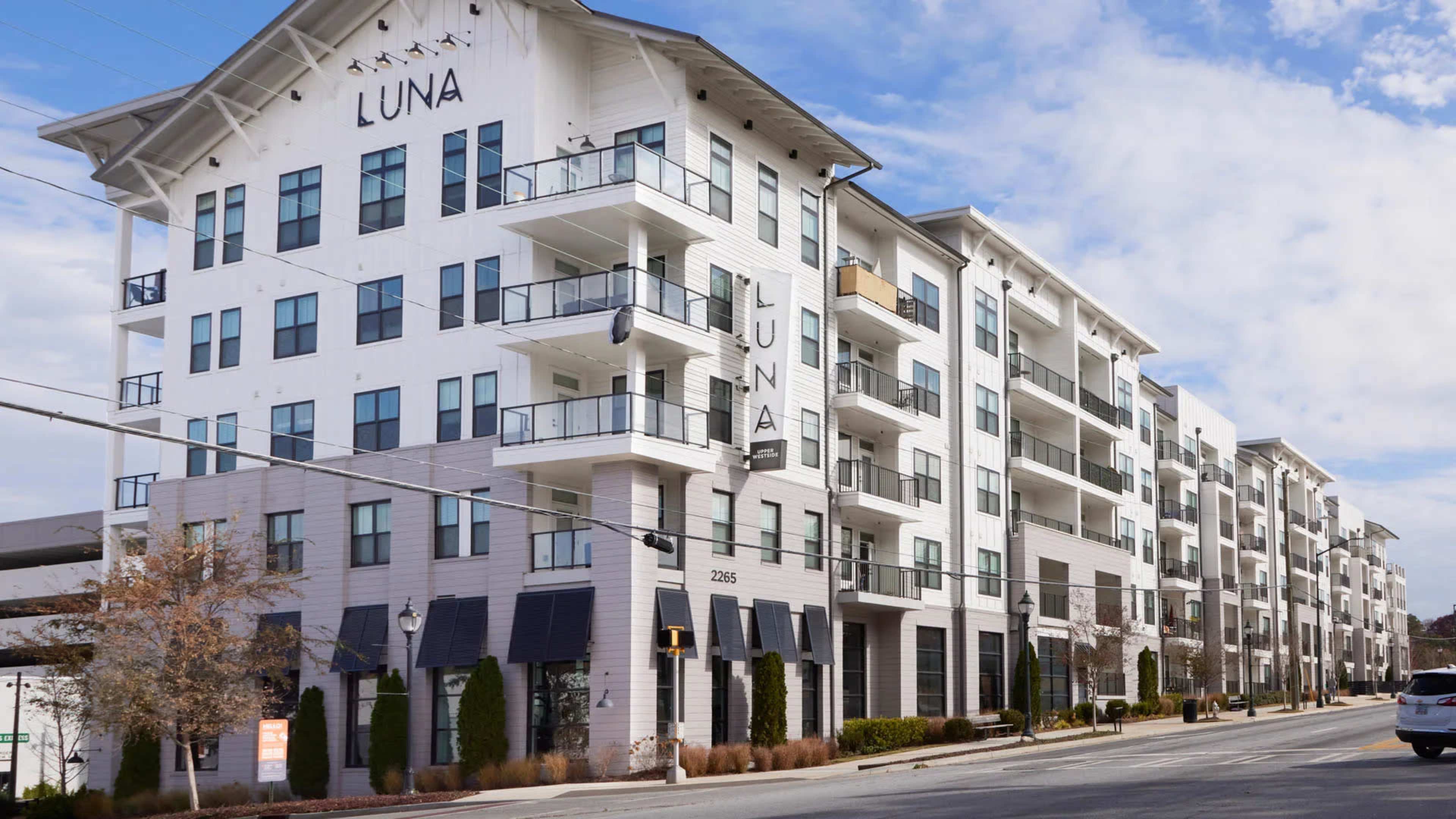A modern, multi-story apartment building named "Luna" with balconies and large windows.