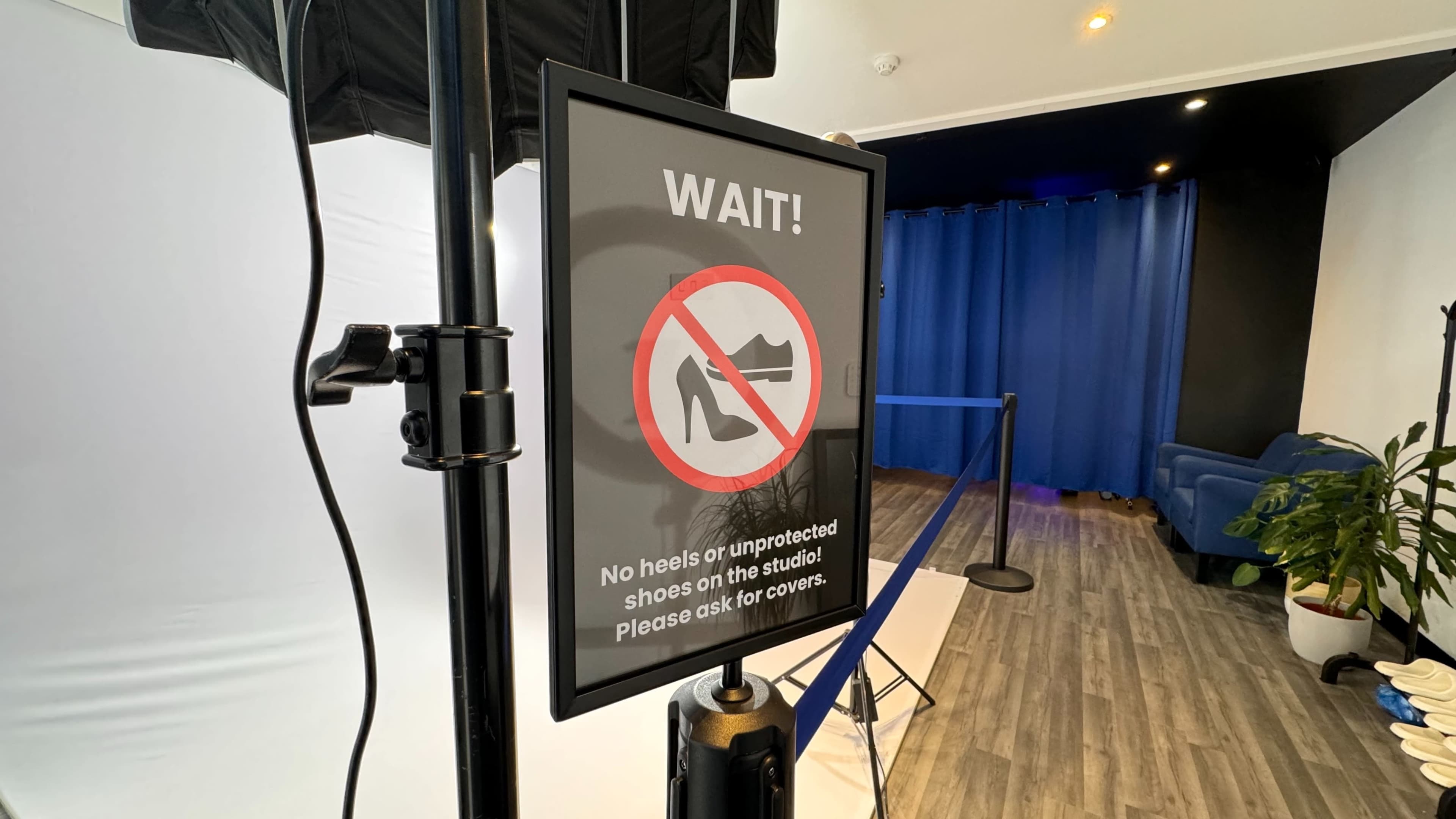 A sign with a "no heels" symbol is displayed in a studio entrance, indicating that unprotected shoes are not permitted.