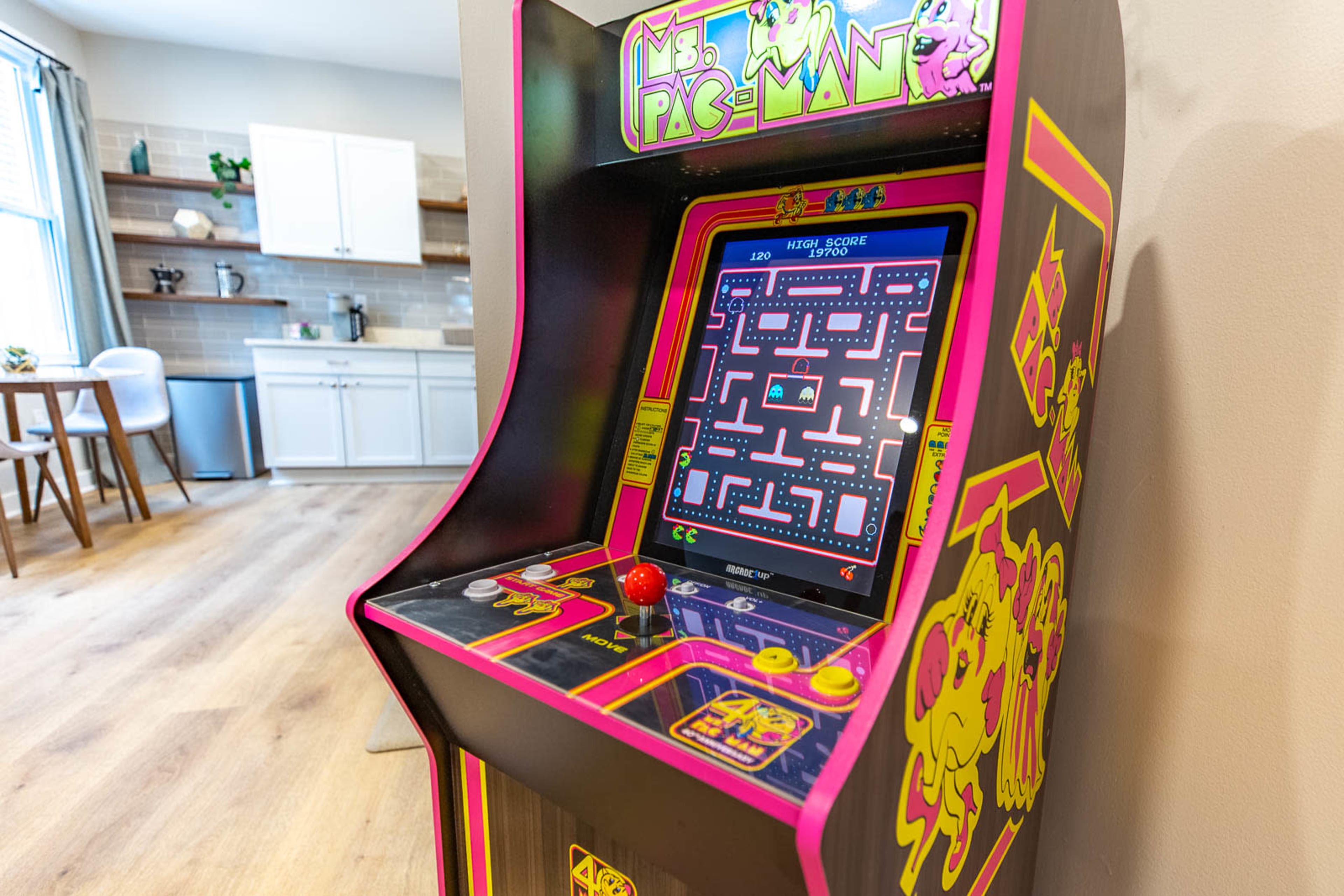 A Ms. Pac-Man arcade game machine in a modern kitchen area.