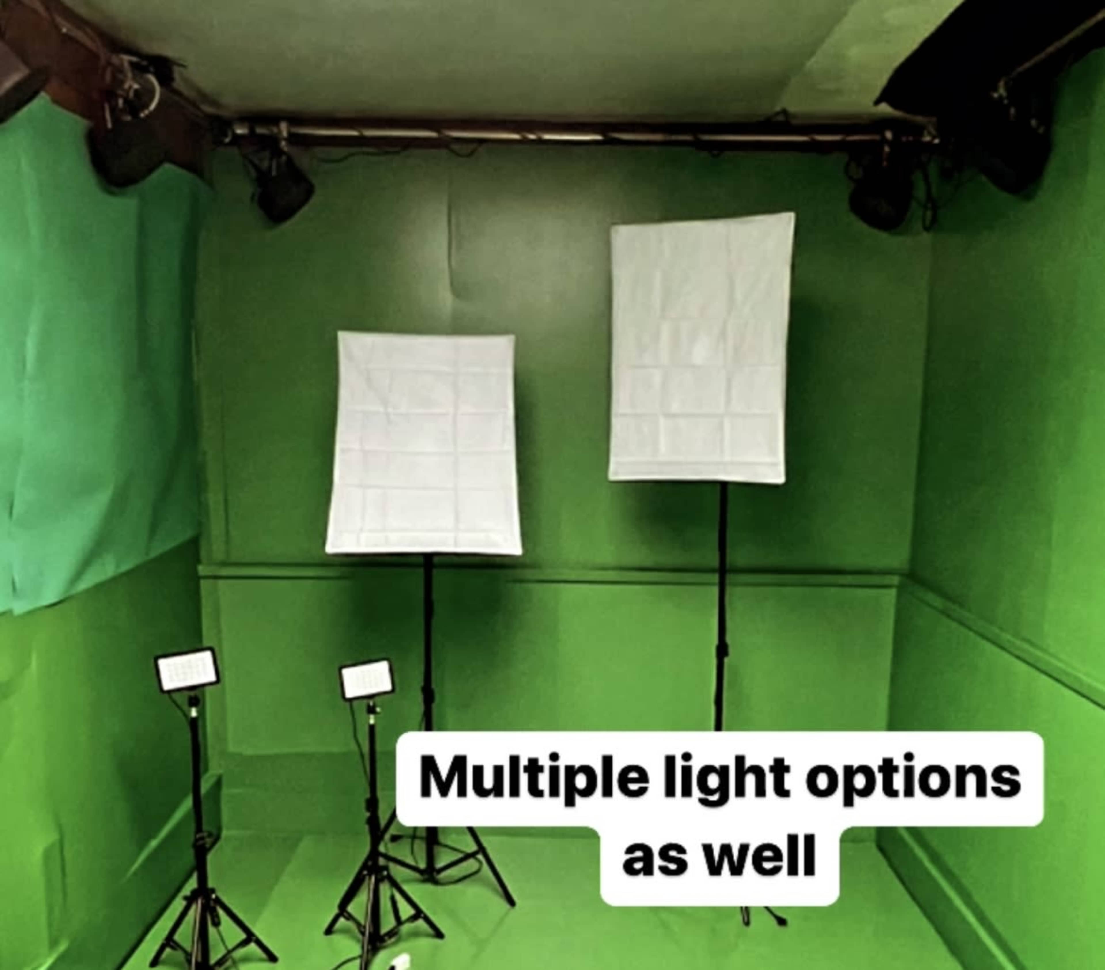 A green room equipped with two large light diffusion panels and several floor lights.