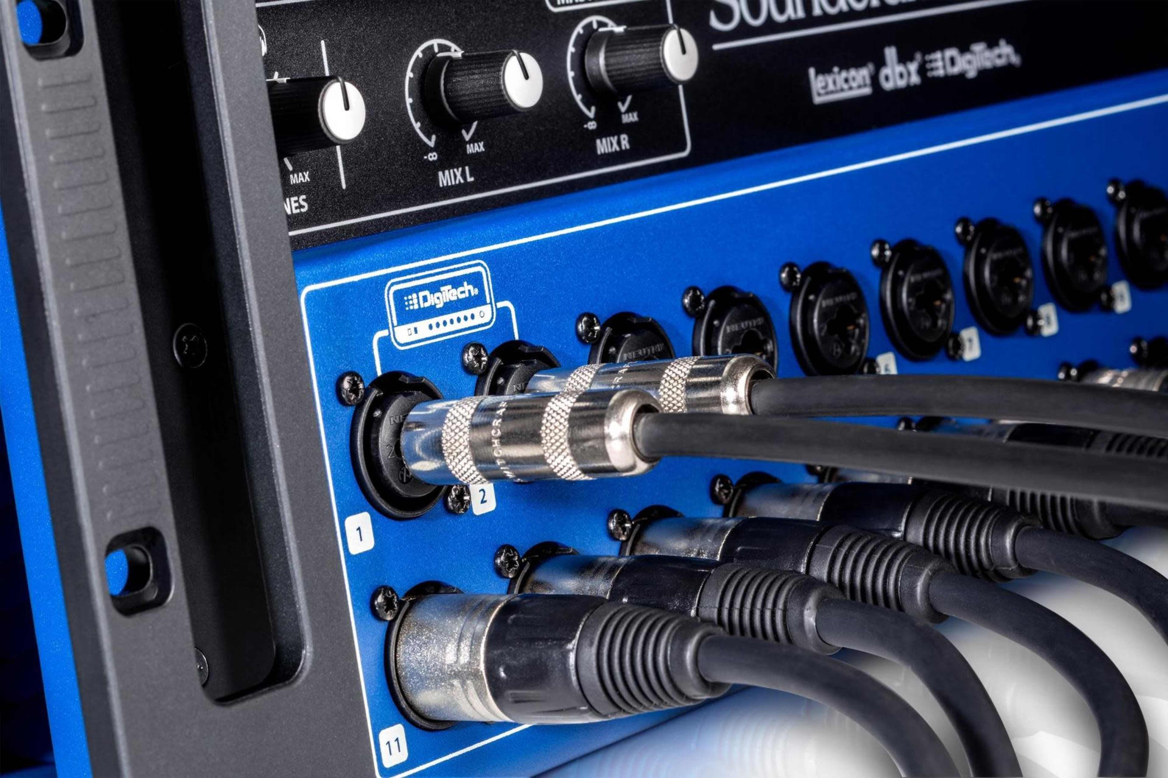 A close-up of audio equipment with multiple cable inputs connected to a blue and black mixer panel.