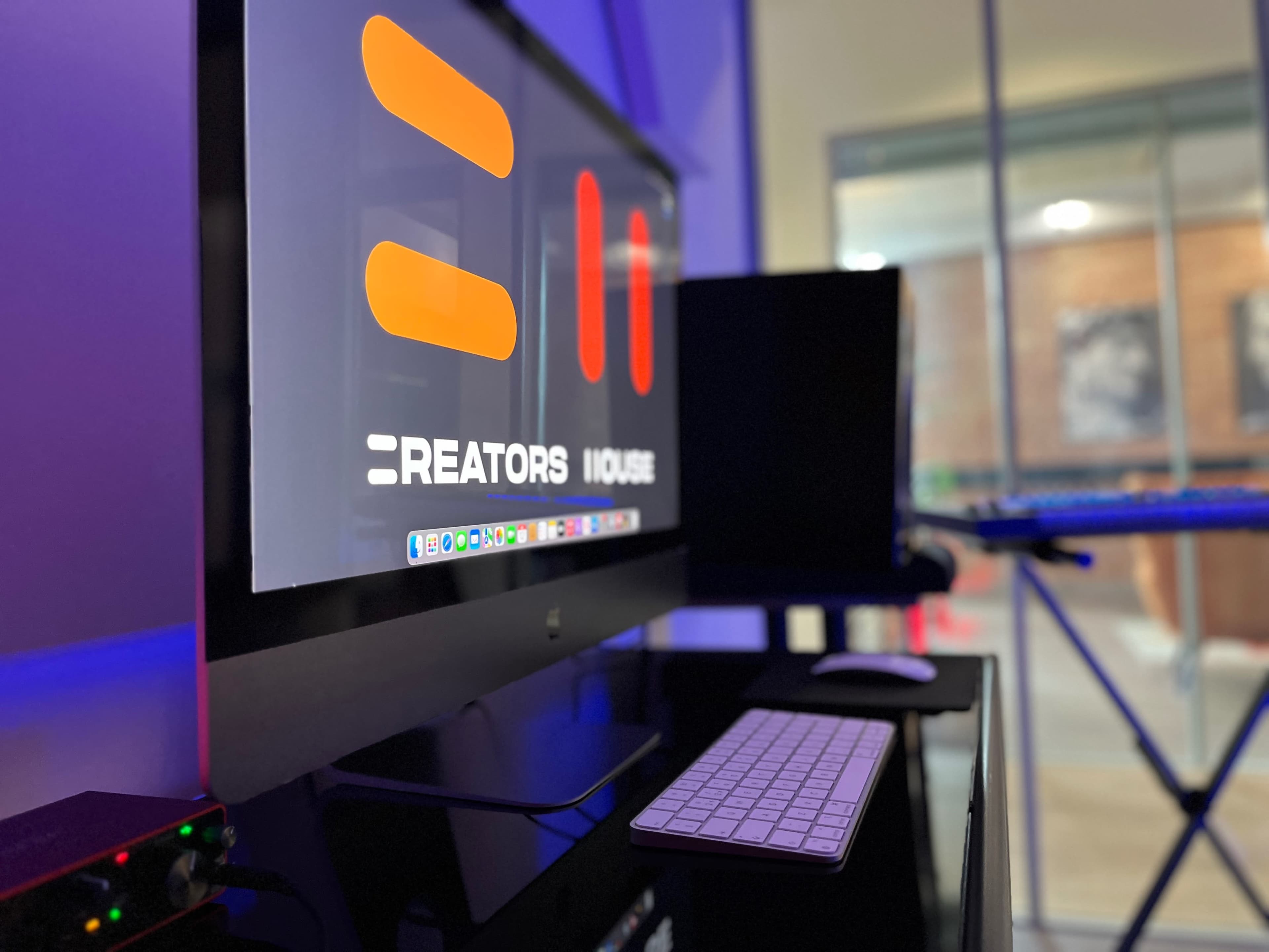 A computer monitor displays the logo for "Creators House" with a keyboard and other equipment visible in a modern workspace.