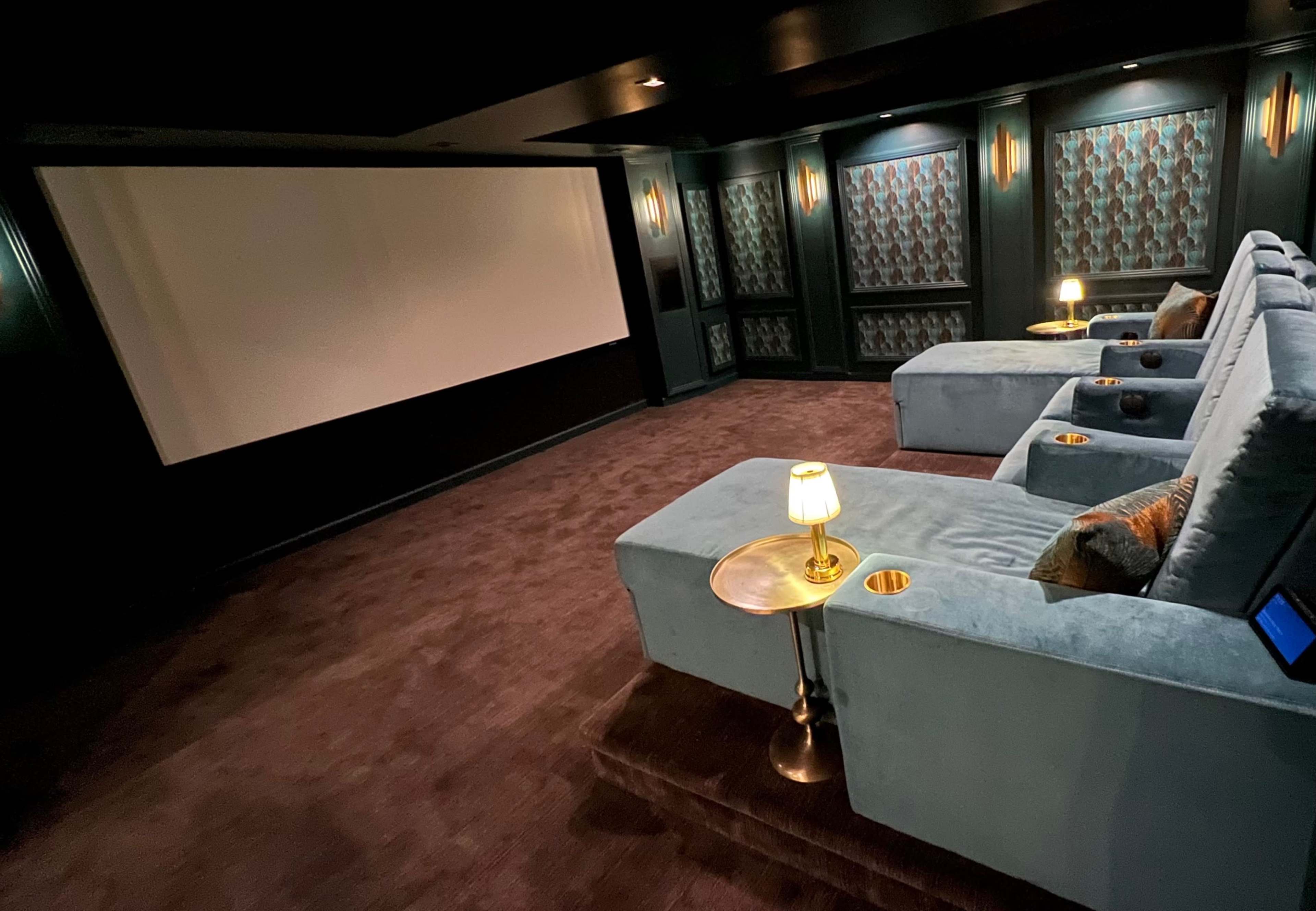 A luxurious home theater with a large screen, plush seating, and elegant decor.