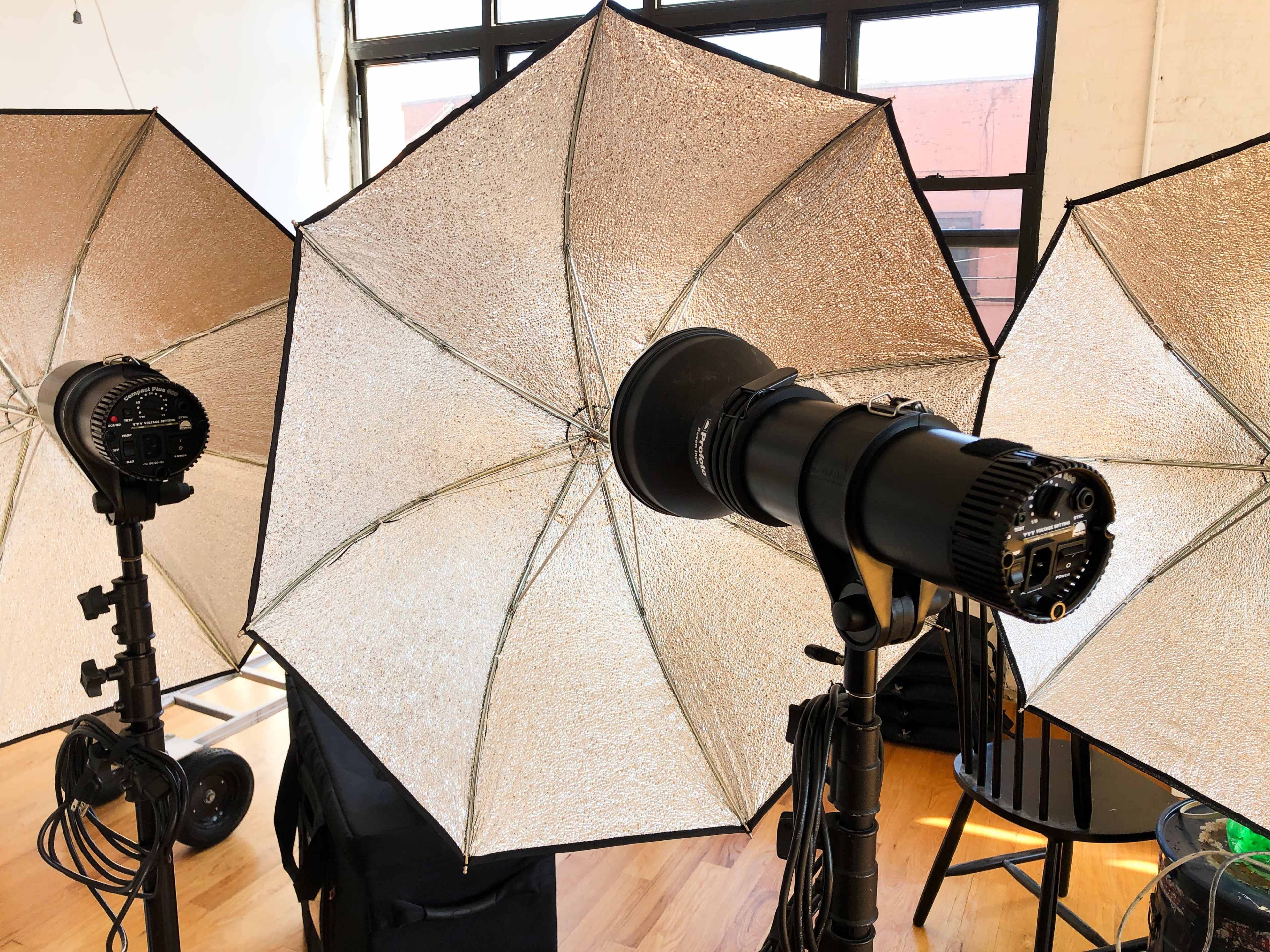 Three studio softbox lights arranged in a well-lit indoor setting.