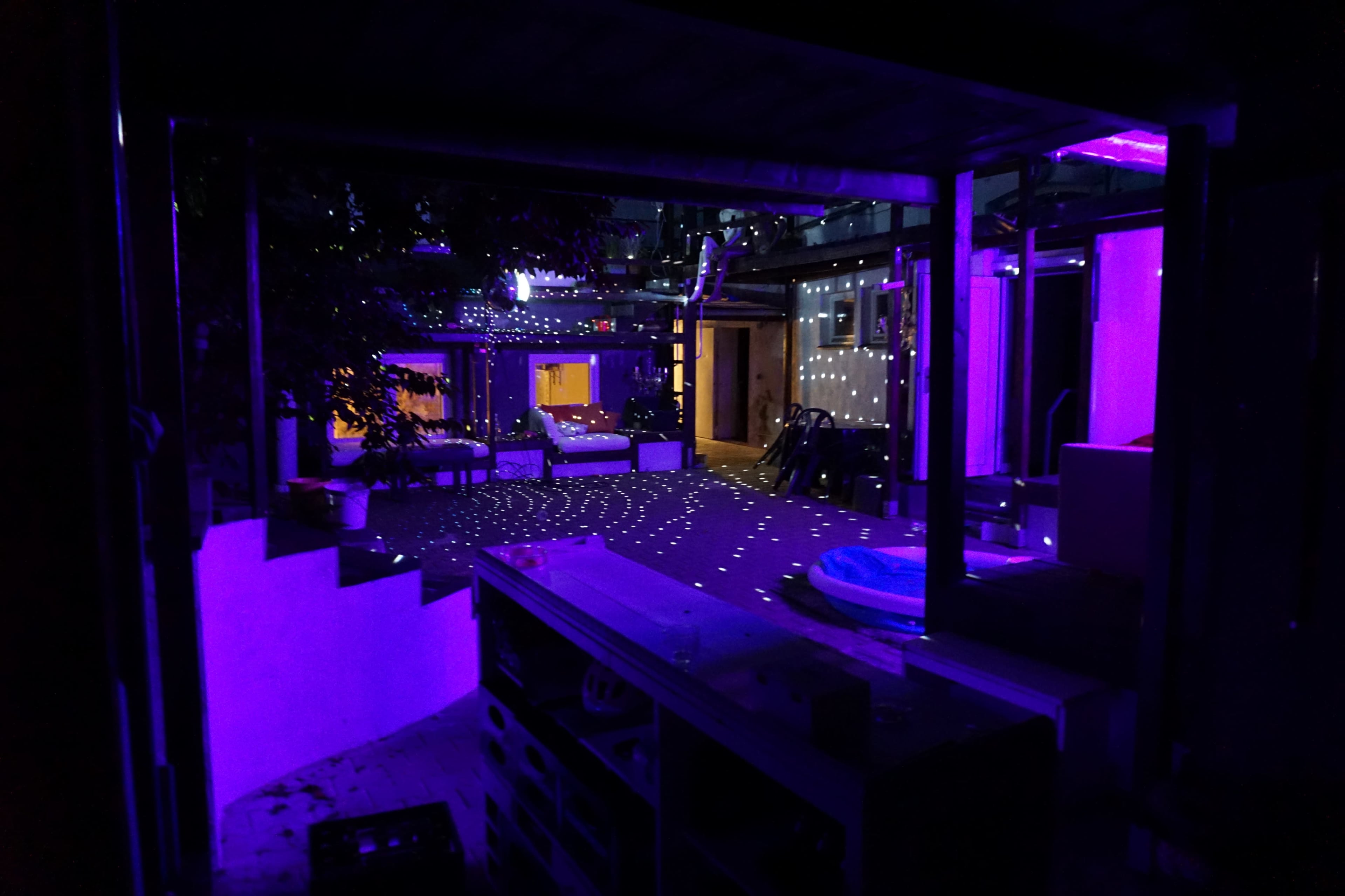 The scene depicts a dimly lit outdoor area with purple lighting creating star-like patterns on the ground and walls.