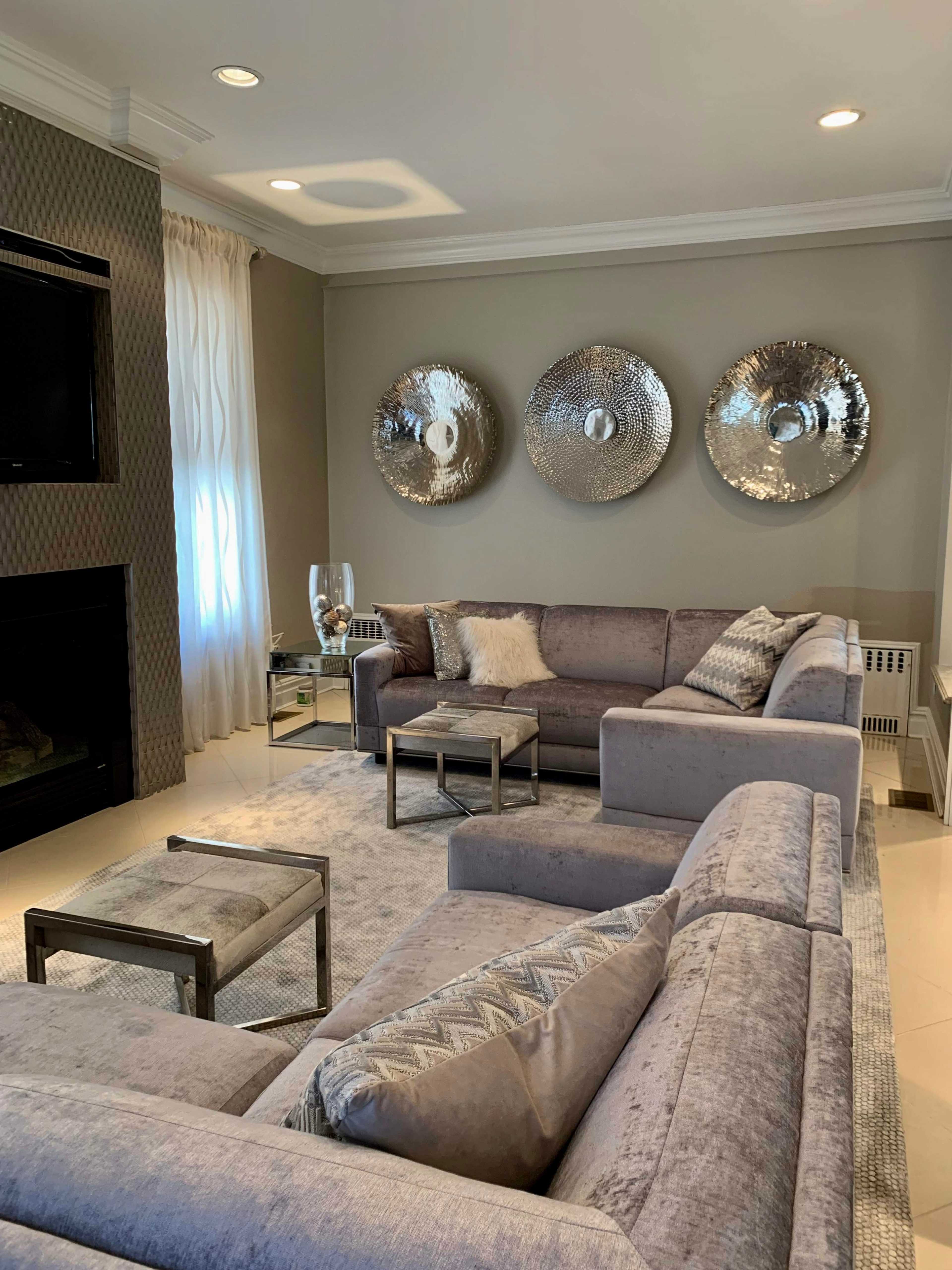 A modern living room with a sectional sofa, a coffee table, and three decorative circular wall hangings.