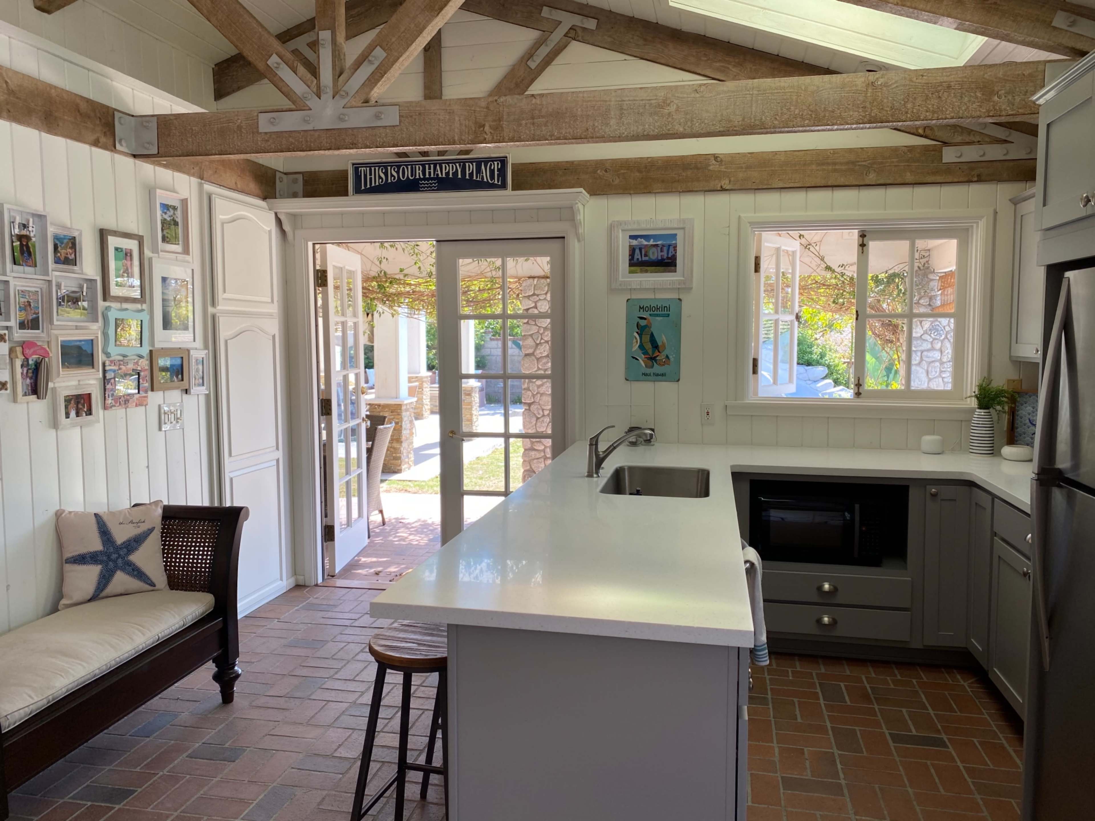 The kitchen features a center island with a sink and a view of a patio through glass doors.