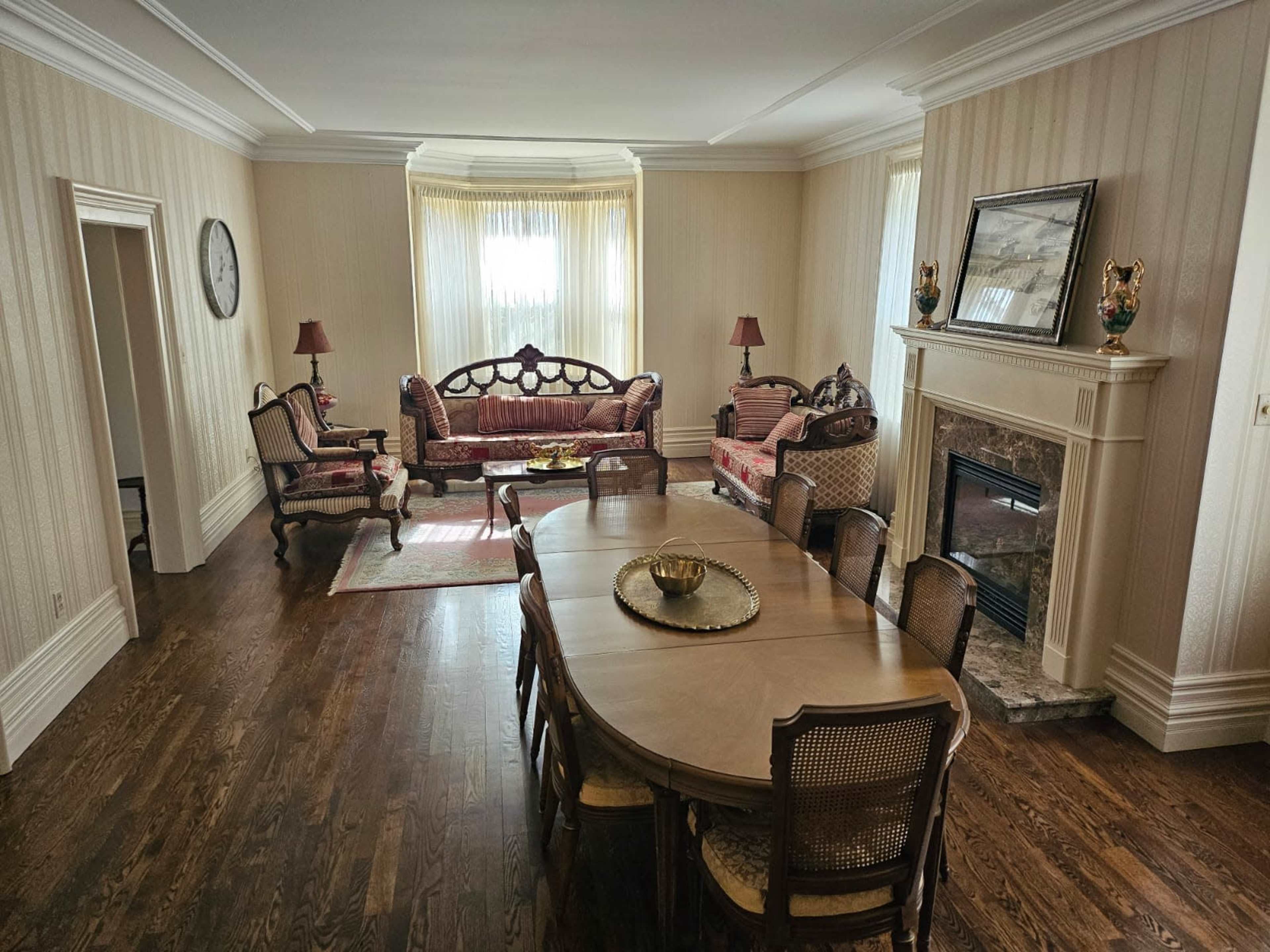 A well-furnished living room with a dining table and chairs, two sofas, and a fireplace.
