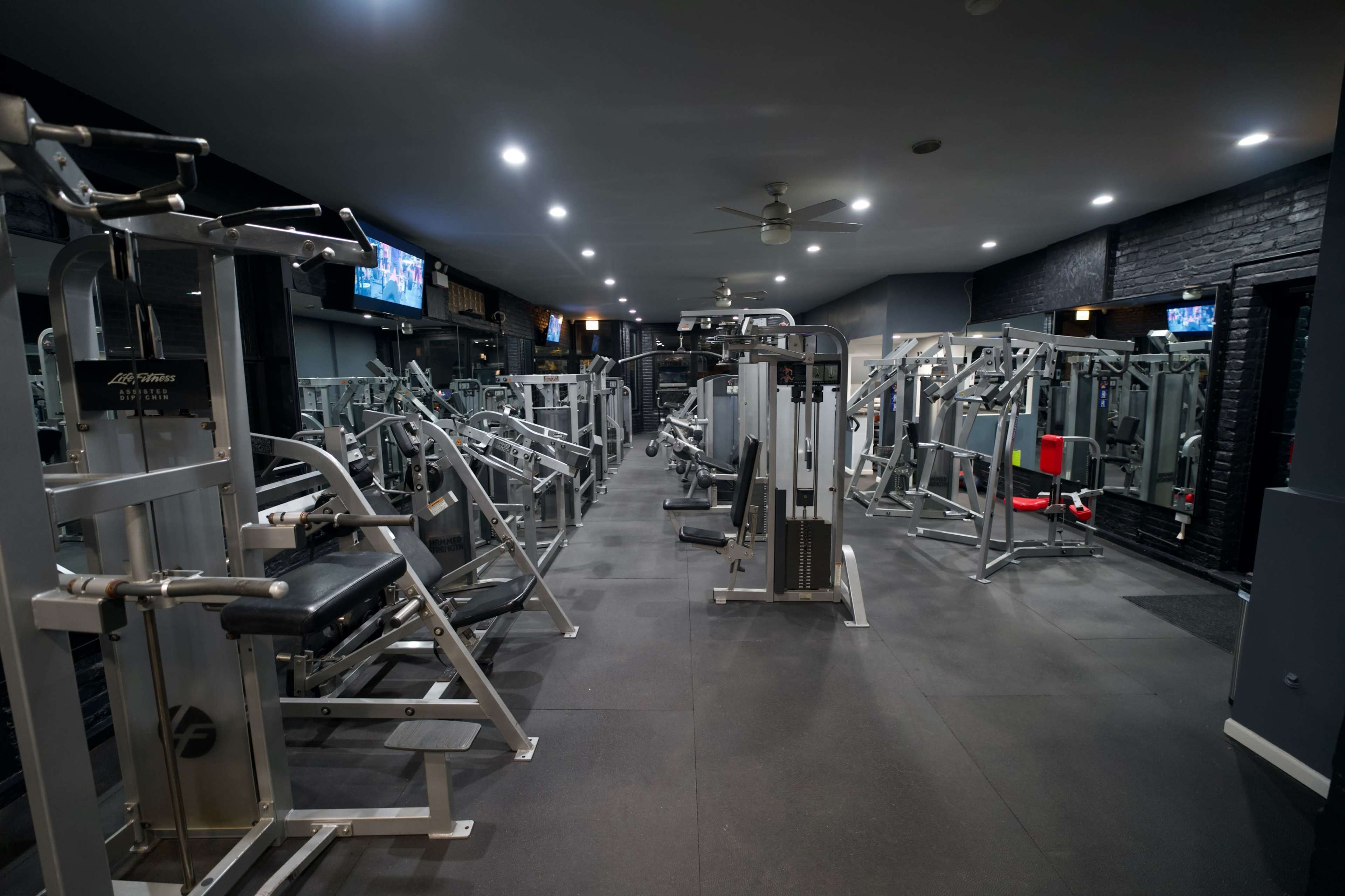 An empty gym filled with various exercise machines and equipment.