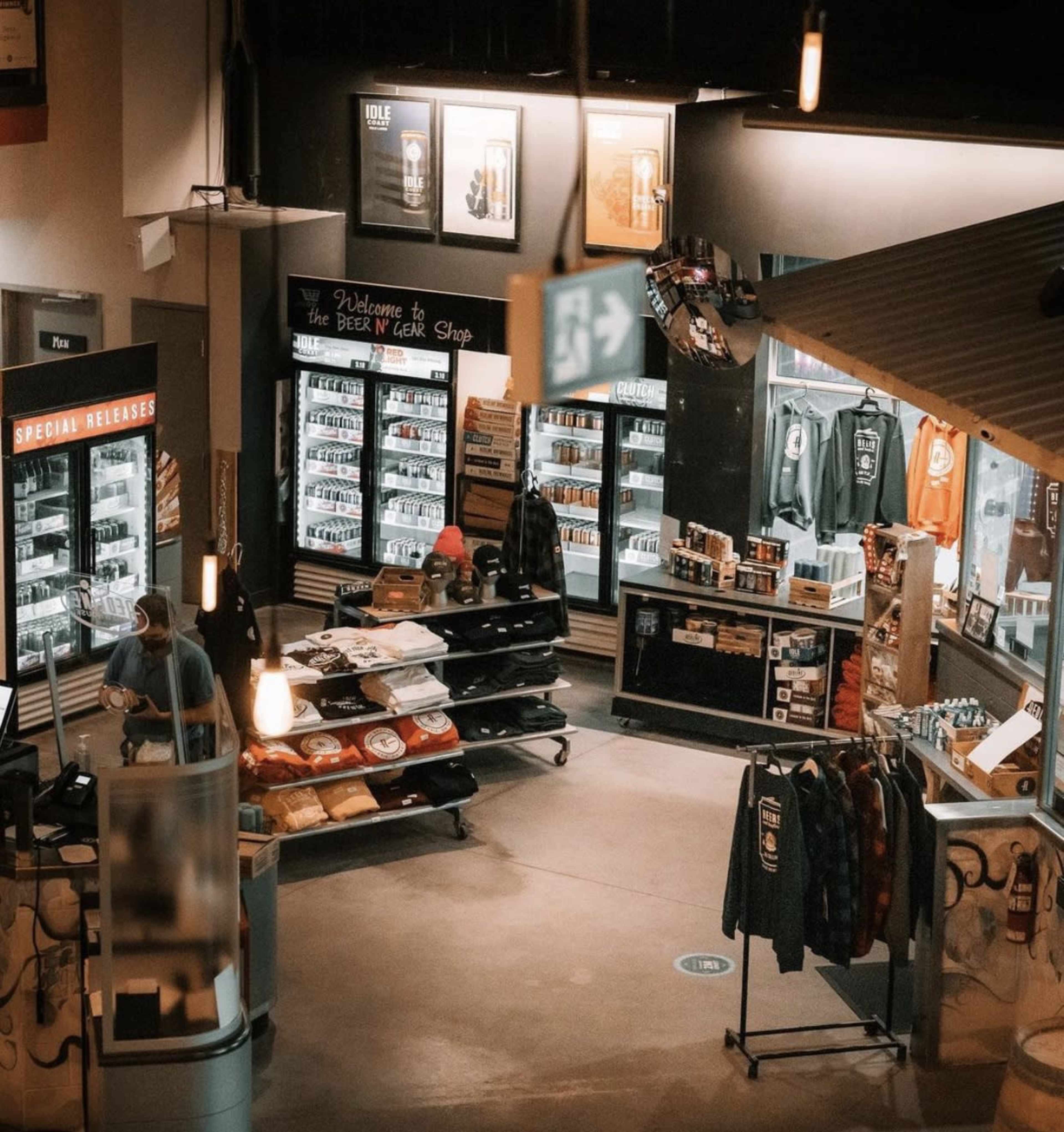 A retail space filled with display refrigerators and merchandise racks, featuring a section labeled "Beer Shop" and various items for sale.