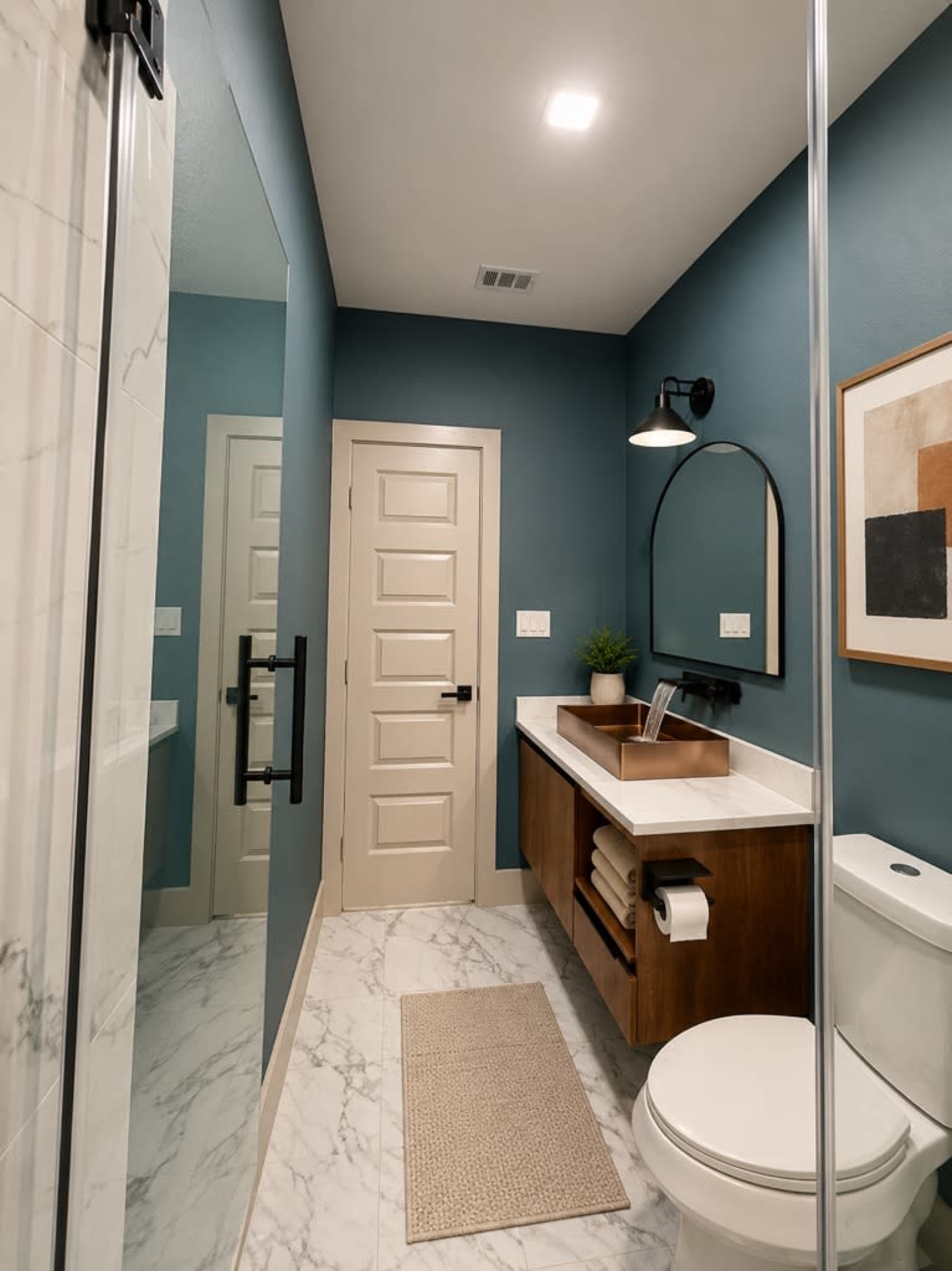 The image shows a modern bathroom featuring a glass shower, a wooden vanity with a countertop, and a toilet, all set against teal-painted walls and marble flooring.
